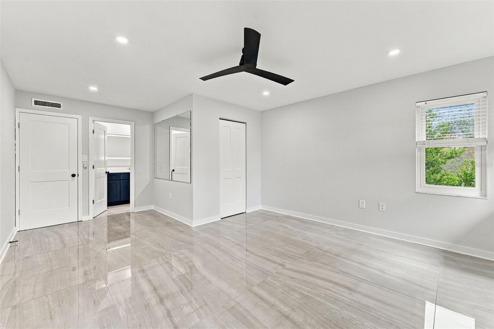 Generously sized primary bedroom with new flooring, lighting and ceiling fan - 2650 COUNTRYSIDE BLVD #A306, CLEARWATER