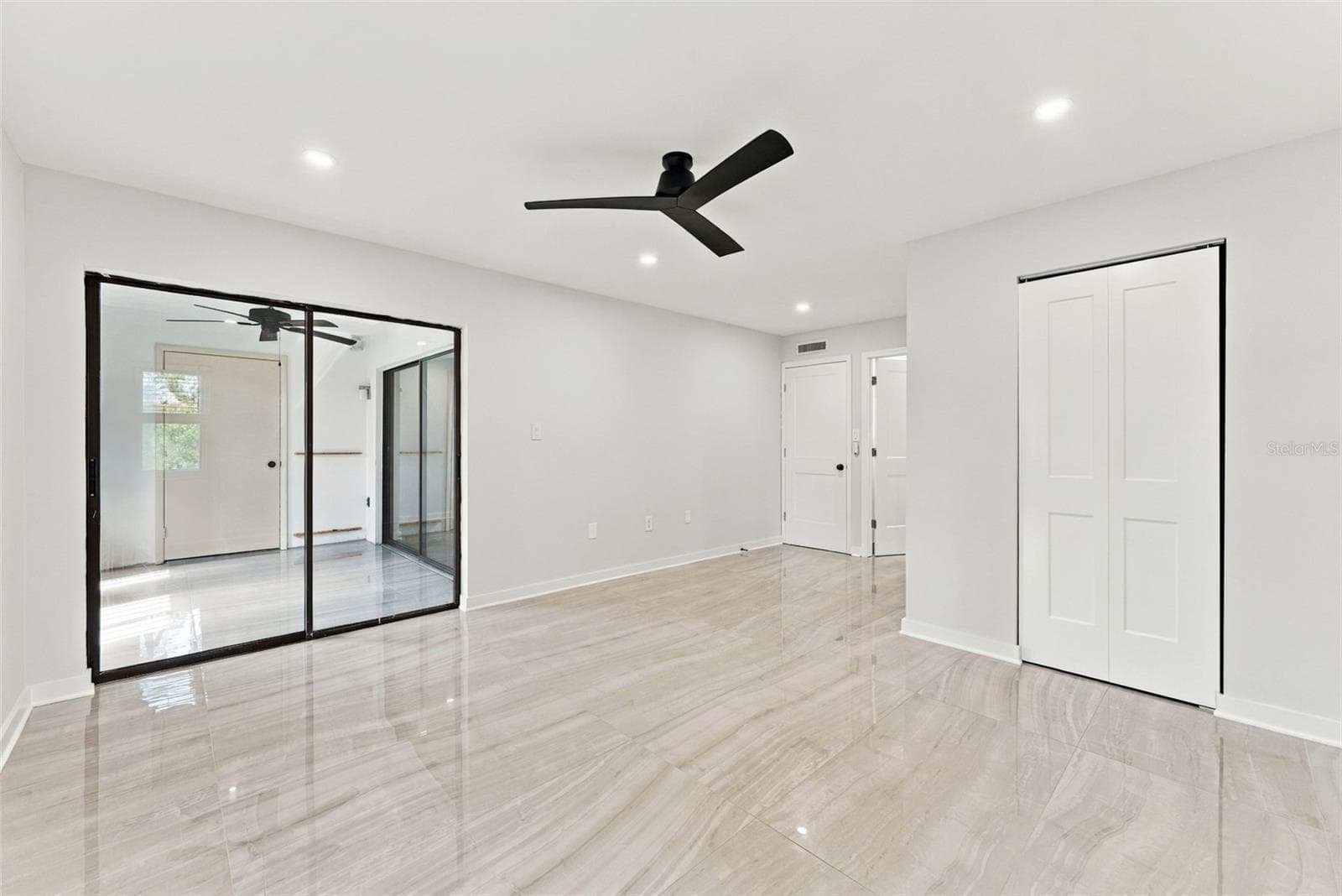Primary bedroom with sliding glass doors opening to the patio - 2650 COUNTRYSIDE BLVD #A306, CLEARWATER