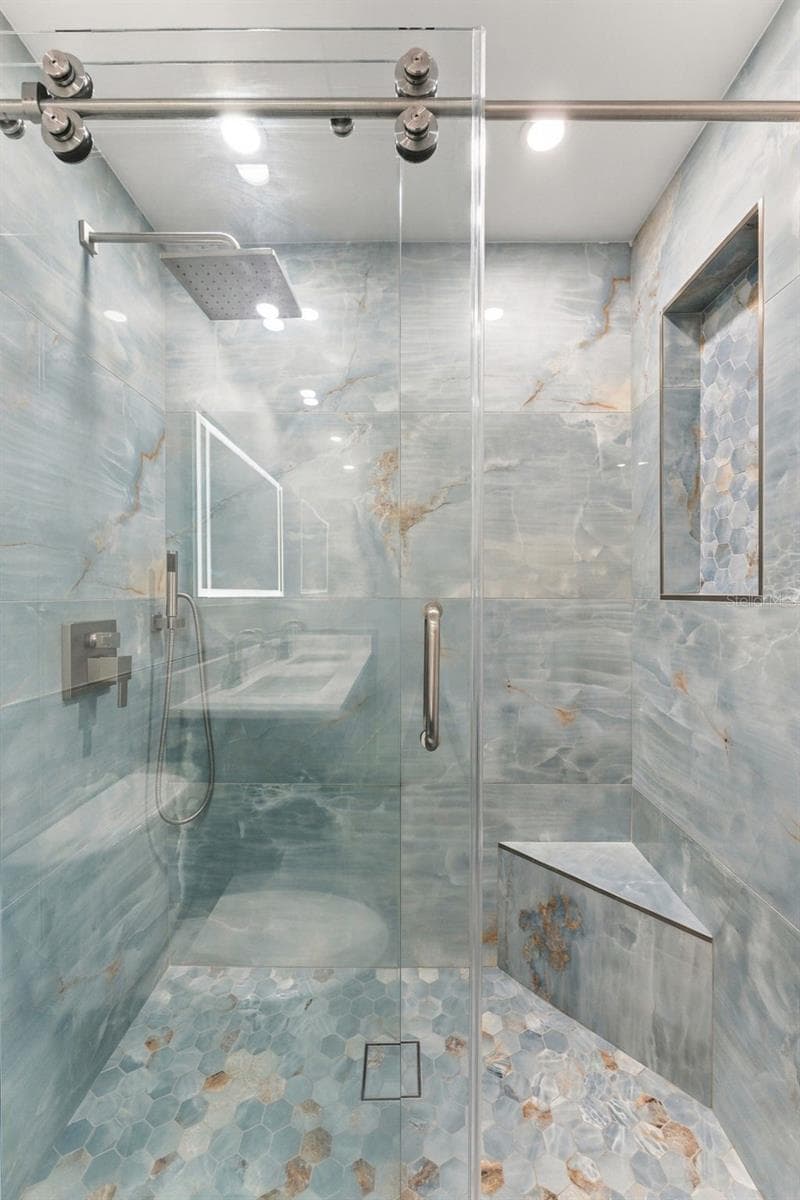 Beautiful primary shower with large glass bypass doors and modern finishes - 2650 COUNTRYSIDE BLVD #A306, CLEARWATER
