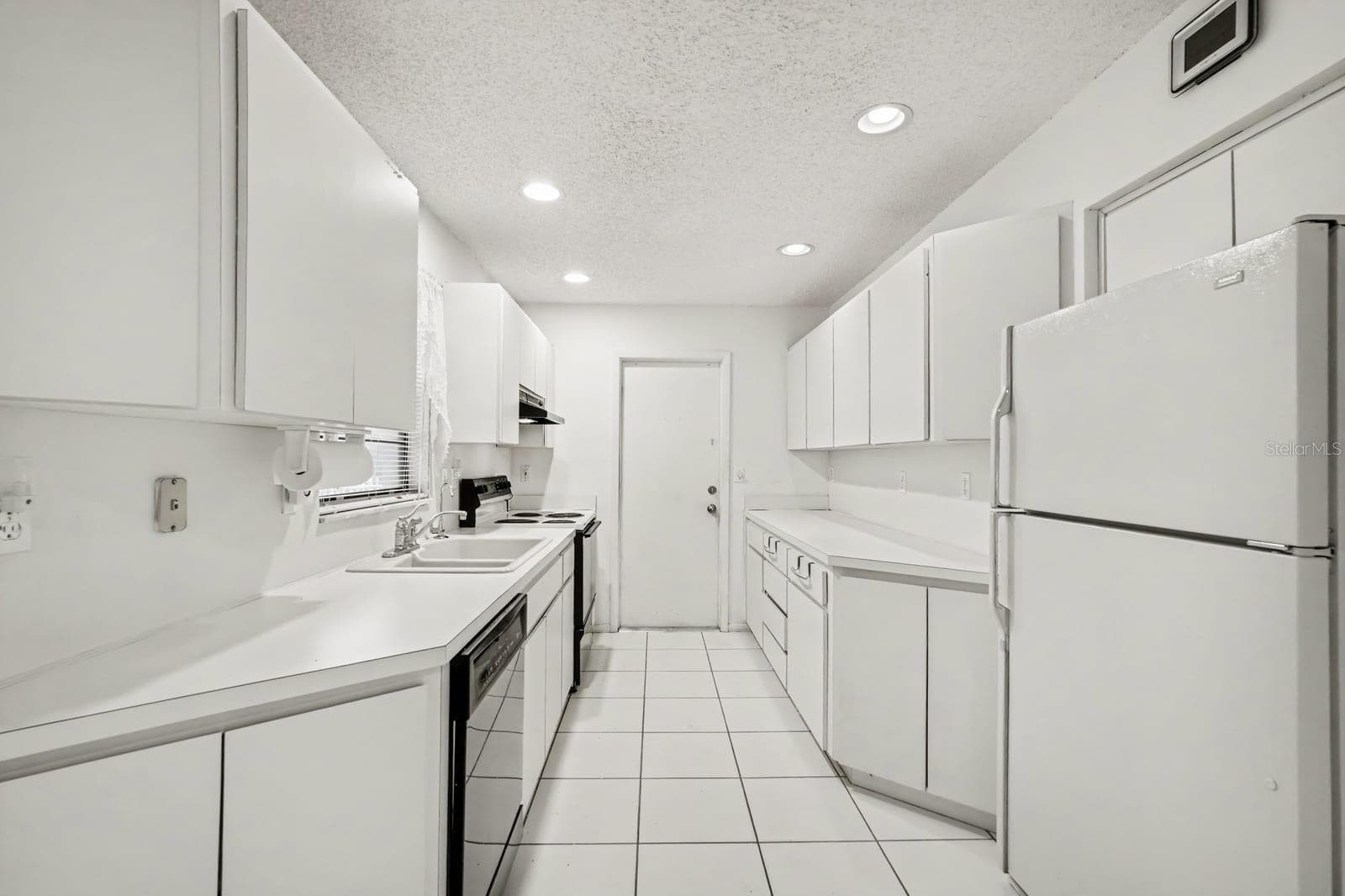 Galley Kitchen with White Cabinetry, Stainless Steel Appliances & Ample Storage - 12128 KATHERWOOD ST #20, SPRING HILL