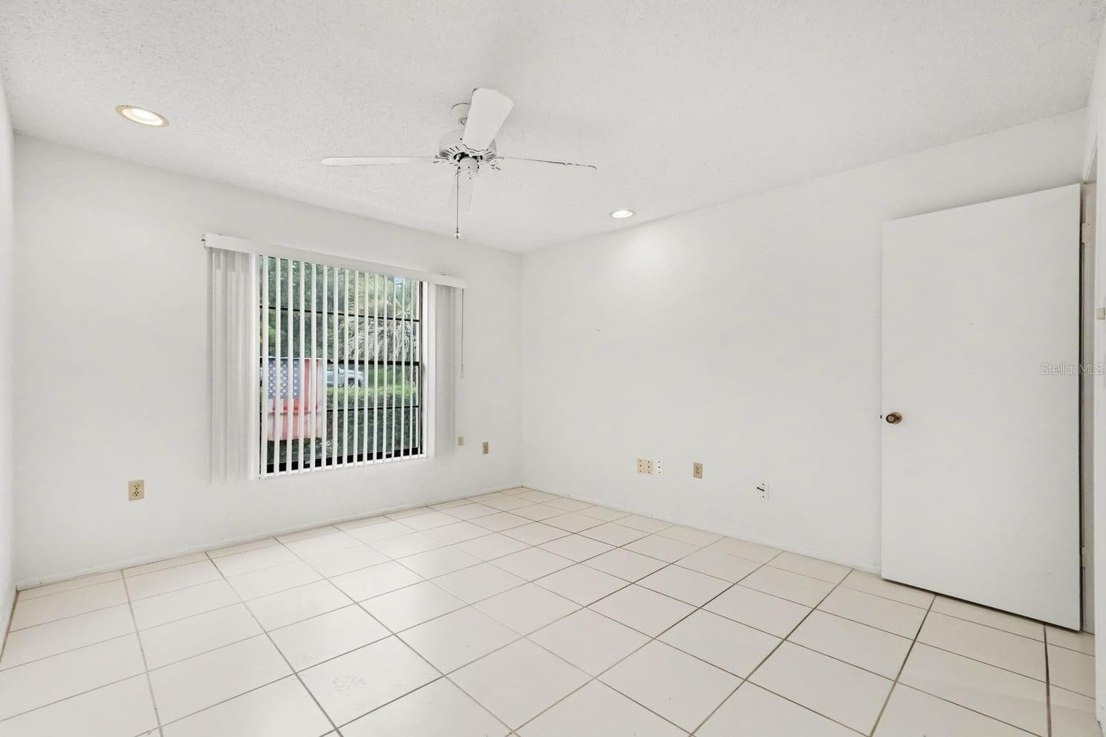 Bright Bedroom with Tile Flooring and Vertical Blinds Overlooking Yard - 12128 KATHERWOOD ST #20, SPRING HILL