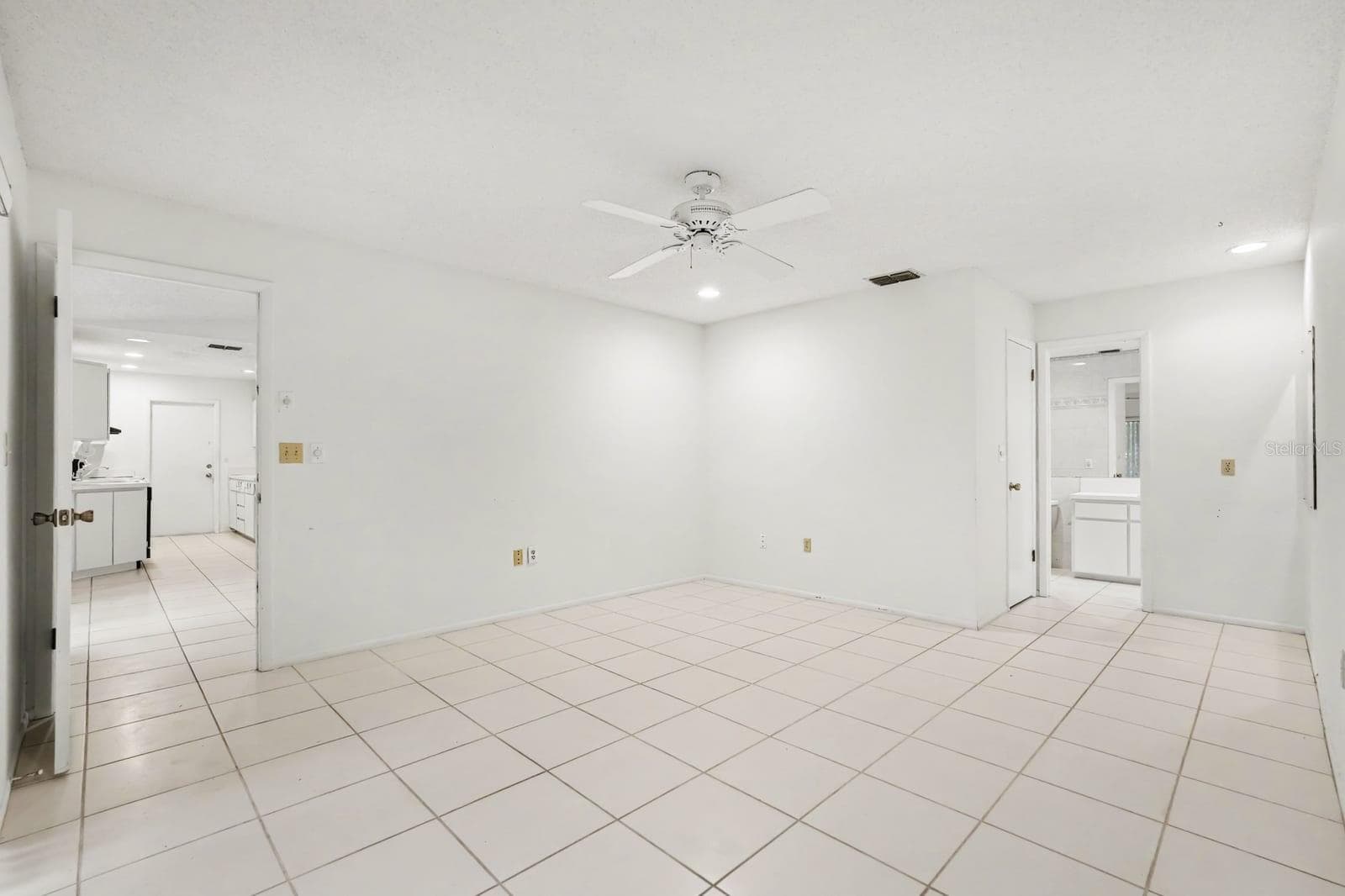 Open Living Area with Tile Floors, Ceiling Fan, and Dual Access Doors - 12128 KATHERWOOD ST #20, SPRING HILL