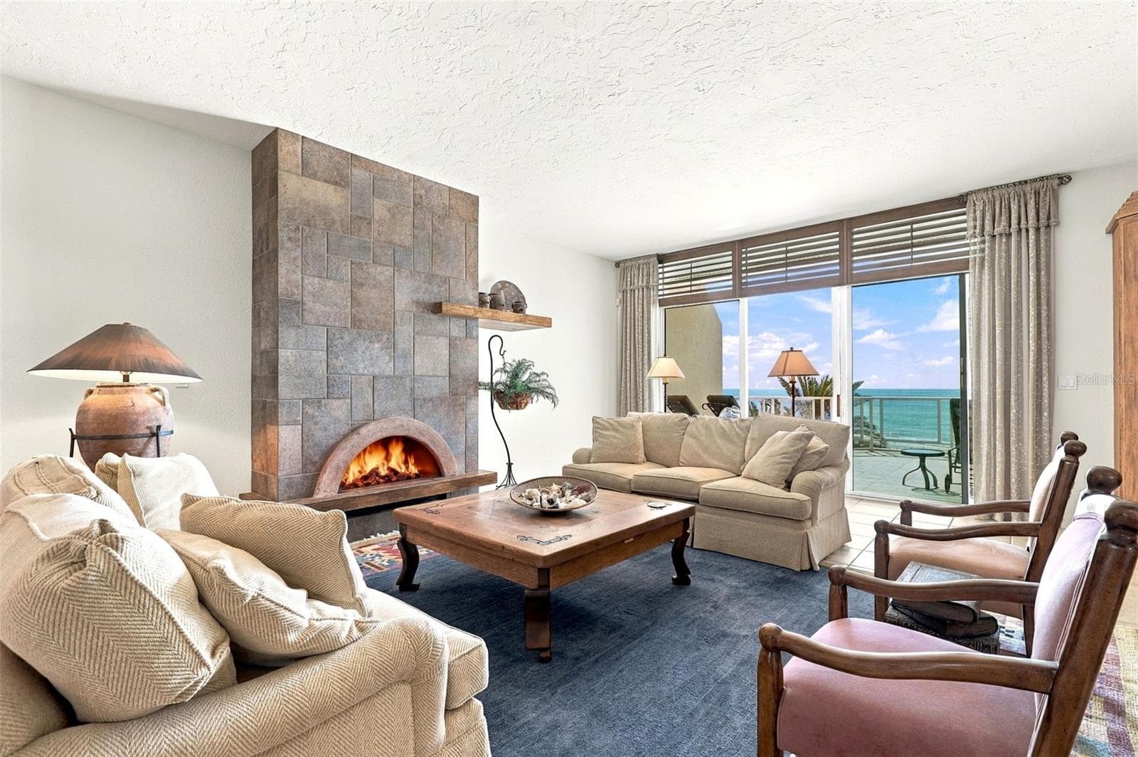 The living room has built-in cabinetry, a gas fireplace, and glass sliders onto a large balcony. - 2185 GULF OF MEXICO DR #243, LONGBOAT KEY
