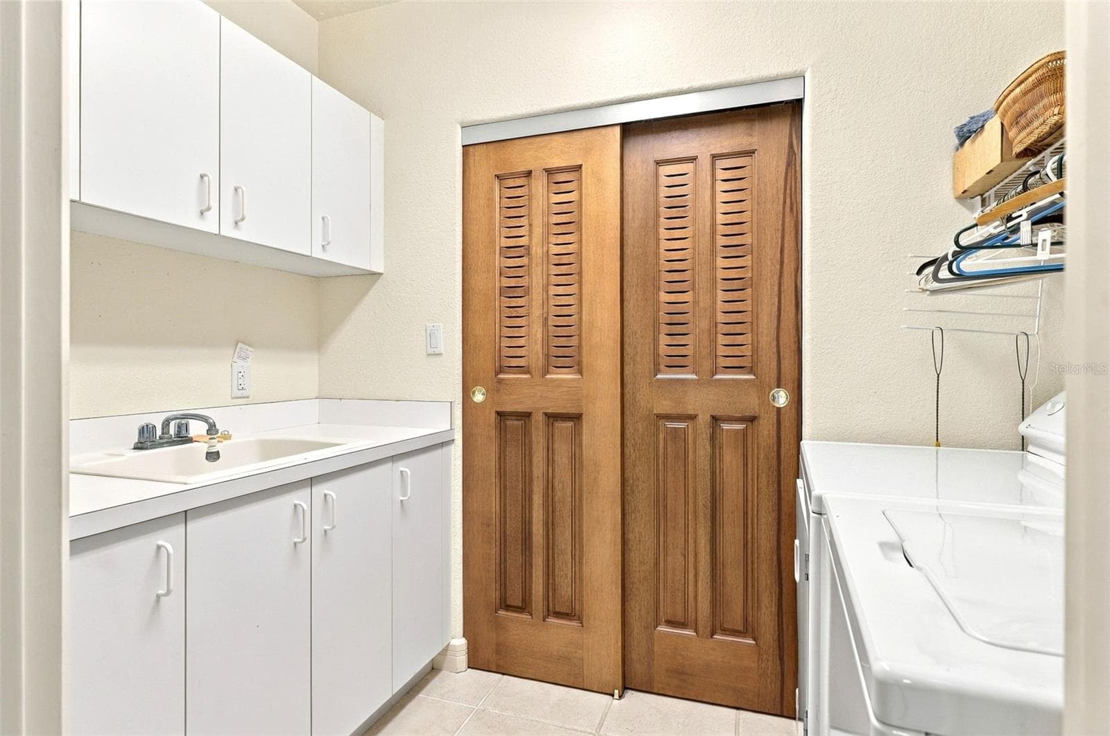 In unit laundry with fitted cabinetry, laundry tub, and utility closet. - 2185 GULF OF MEXICO DR #243, LONGBOAT KEY
