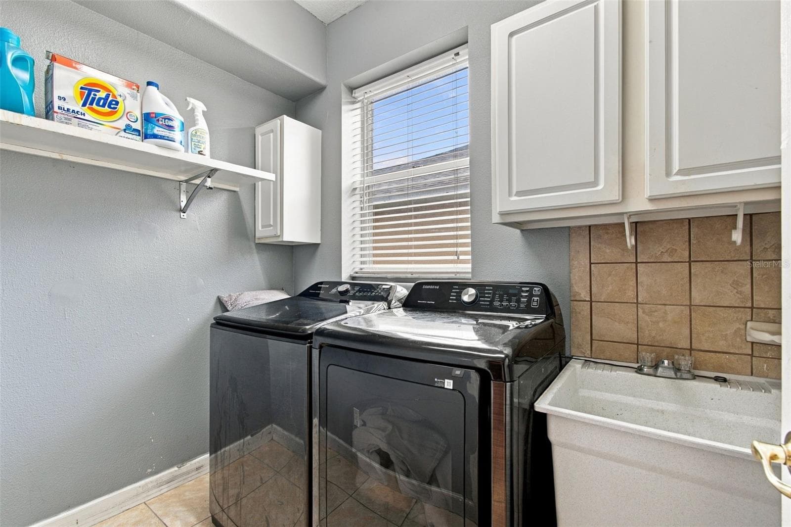 Your laundry room is bright and cheerful with a window and laundry sink. - 19025 FISHERMANS BEND DR, LUTZ