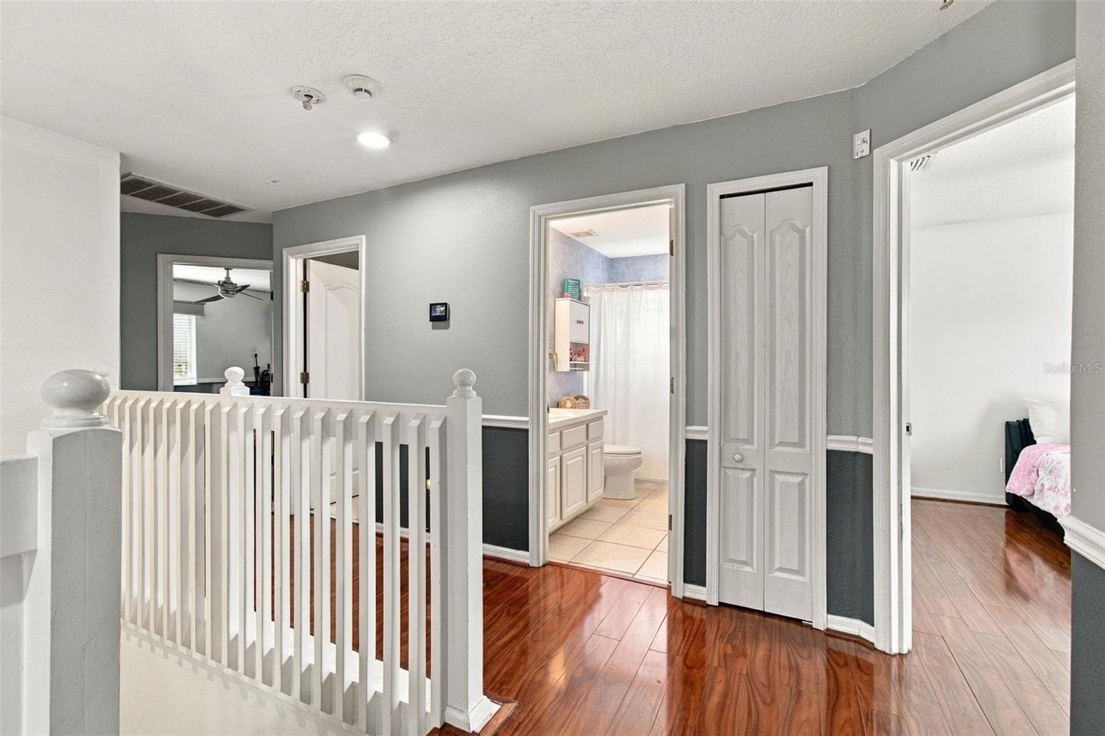 Your second story features a banister balcony, the secondary bedrooms, secondary bathrooms and primary suite. - 19025 FISHERMANS BEND DR, LUTZ