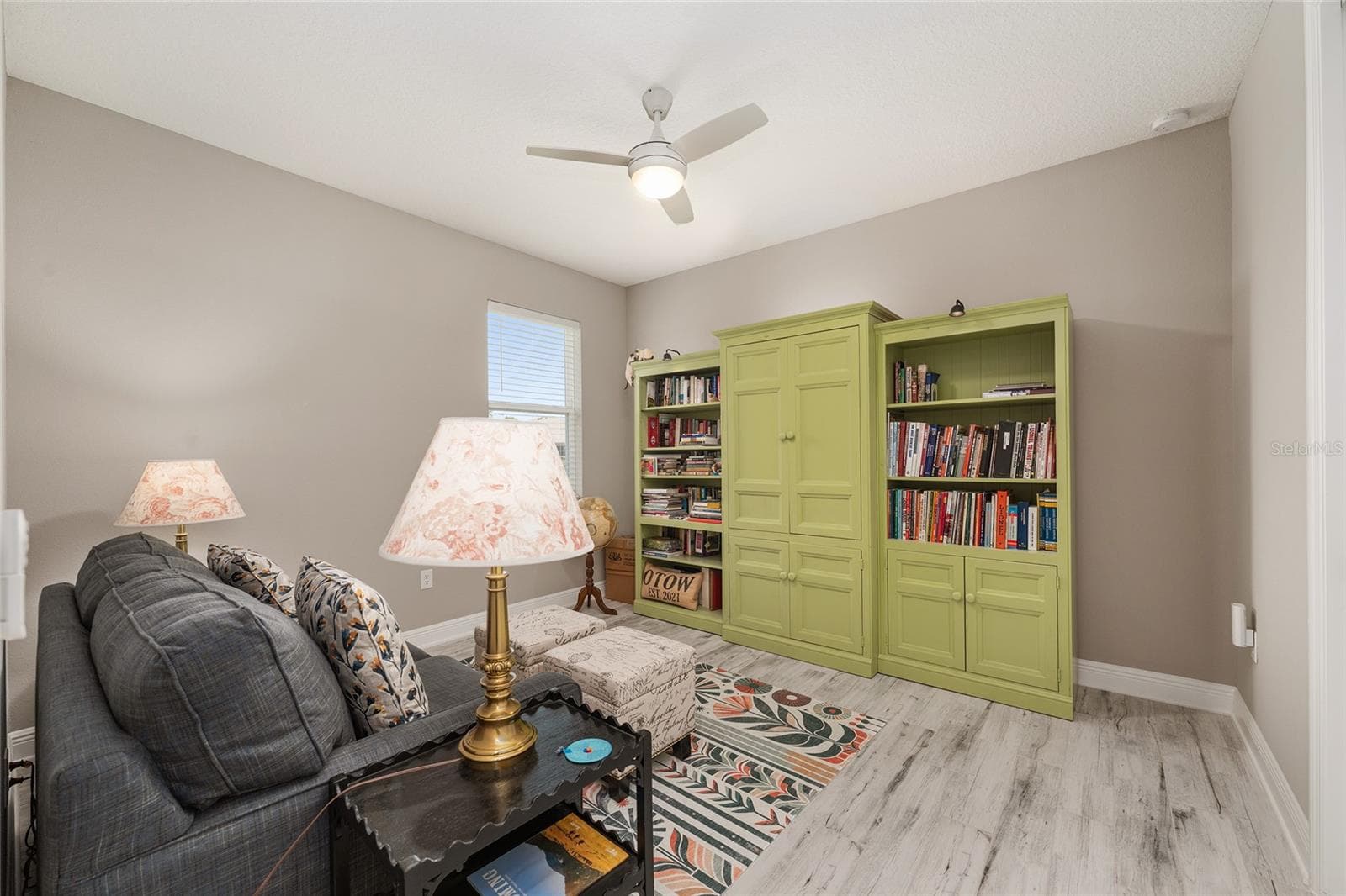 Comfortable third bedroom featuring ceramic plank flooring, ceiling fan with light, neutral finishes, and natural light.currently used as a den - 8290 SW 92ND CIR, OCALA