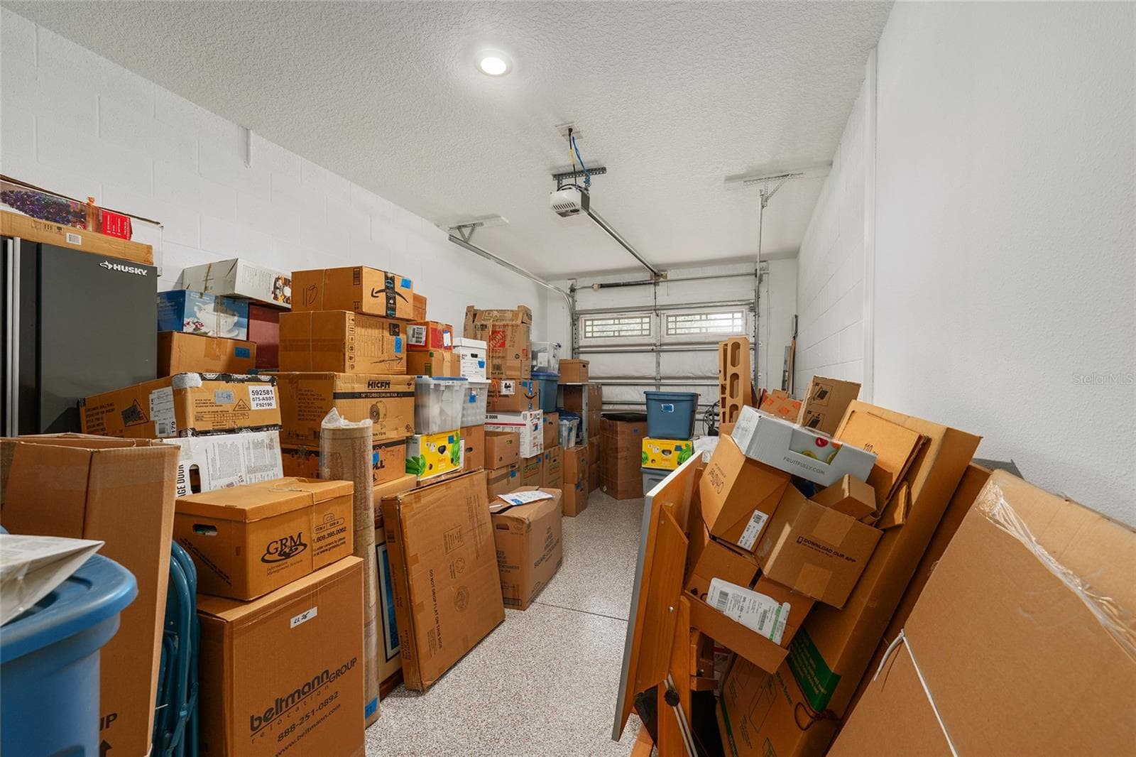 Extra-deep third-car garage featuring epoxy flooring, recessed lighting, and a dedicated golf-cart electrical outlet. Ideal for golf cart parking, an additional vehicle, or generous storage space. - 8290 SW 92ND CIR, OCALA