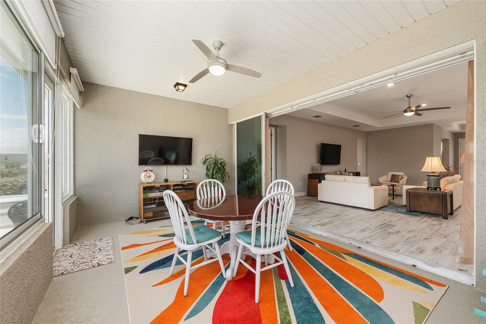 Enclosed lanai featuring expansive stacking sliding glass doors and a zero-entry transition from the great room, creating an effortless flow between the two living spaces—perfect for entertaining and enjoying Florida living year-round. - 8290 SW 92ND CIR, OCALA
