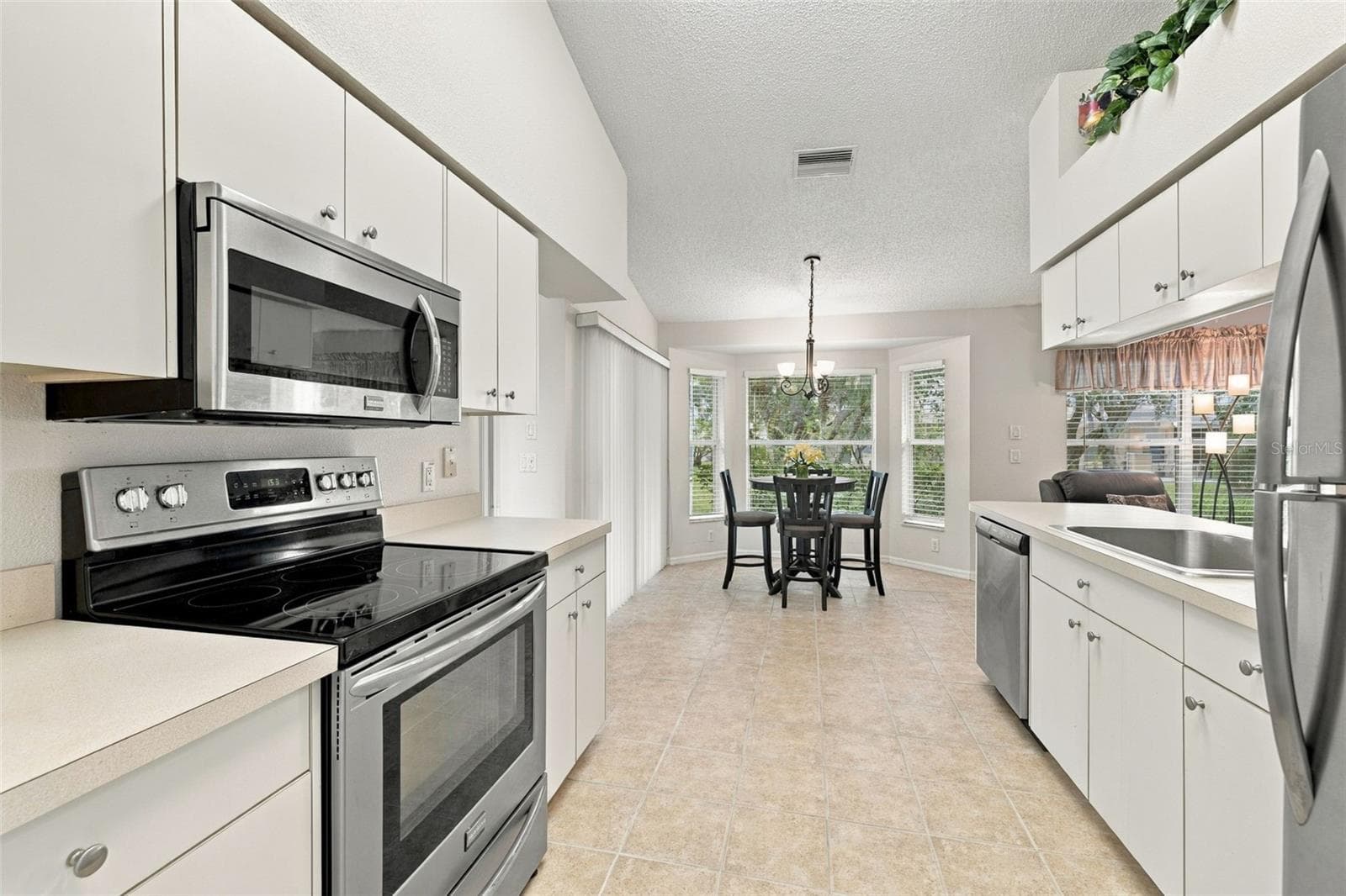 Features stainless-steel appliances and ample cabinet/storage space - 1149 WOLFORD DR, NEW PORT RICHEY