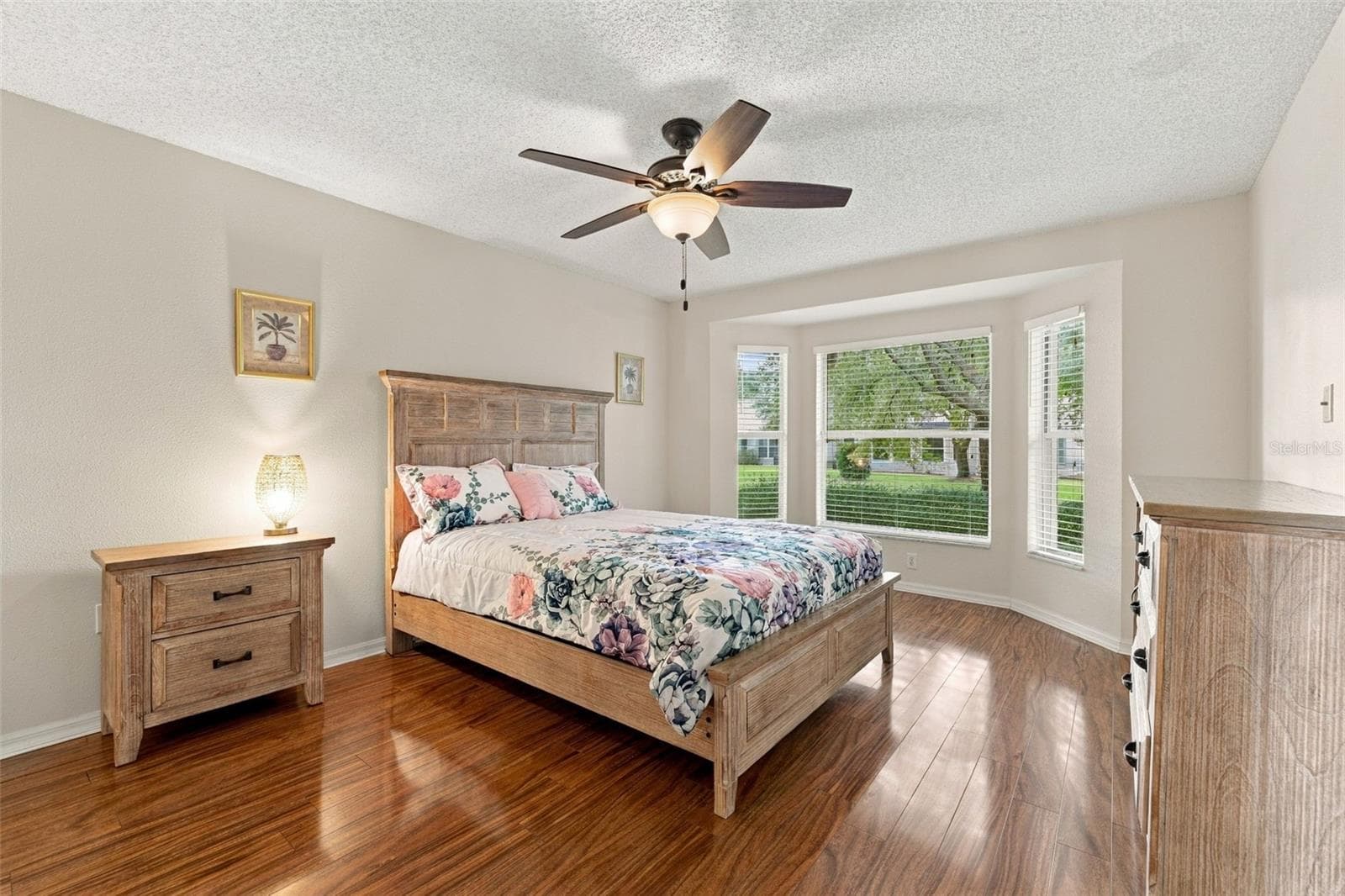 Primary Bedroom with a bay window, ceiling fan and laminate flooring - 1149 WOLFORD DR, NEW PORT RICHEY