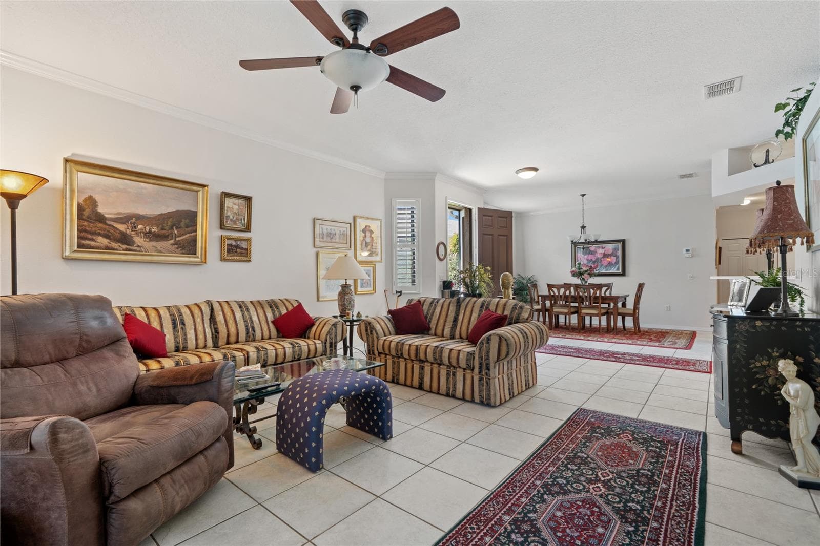 LIVING ROOM WITH VIEW TO DINING ROOM AND FRONT DOOR. - 8112 AMBERSWEET PL, LAND O LAKES