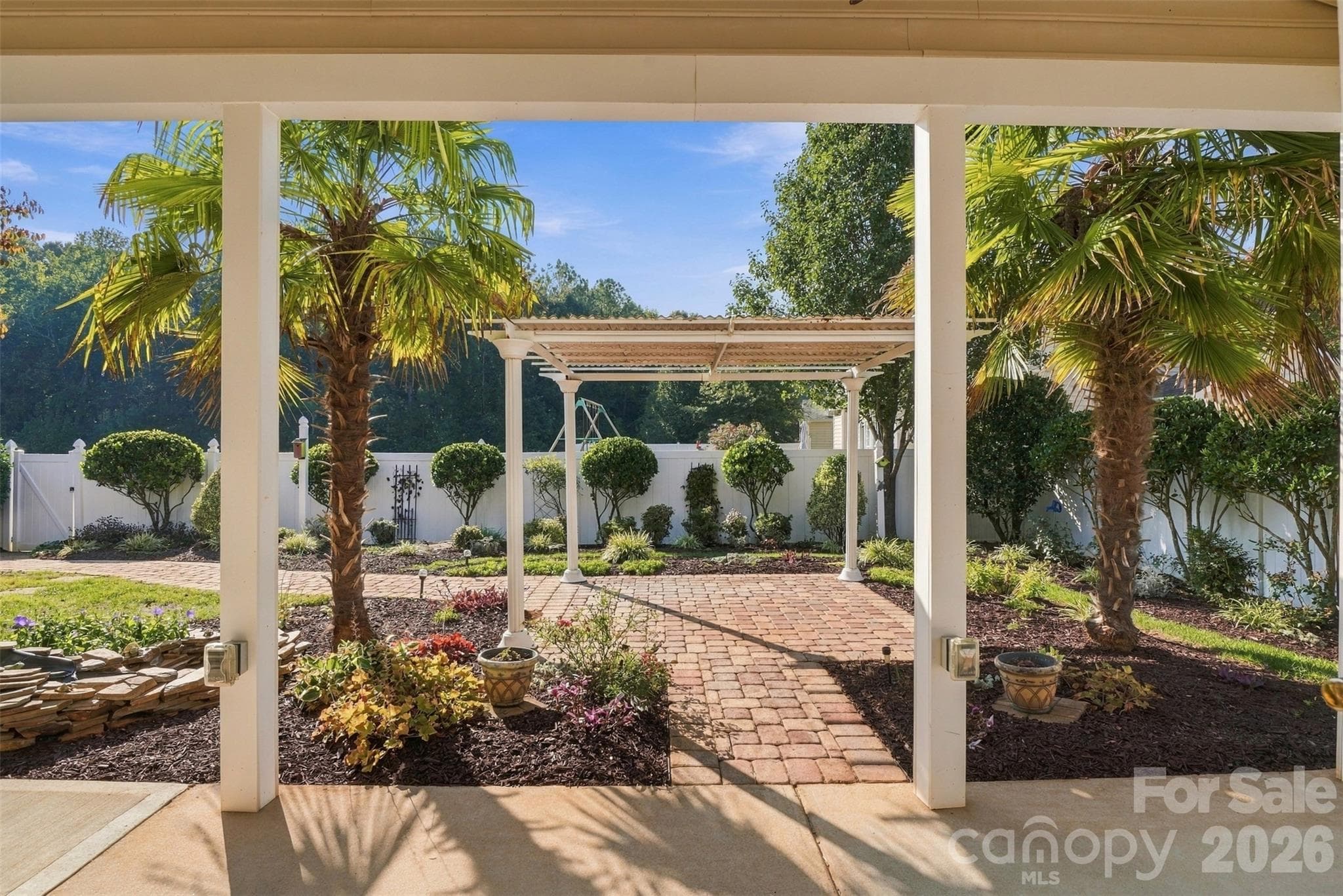 Beautiful pergola and gorgeous gardens with a small stone water feature on the left. - 608 Goldflower Drive, Rock Hill