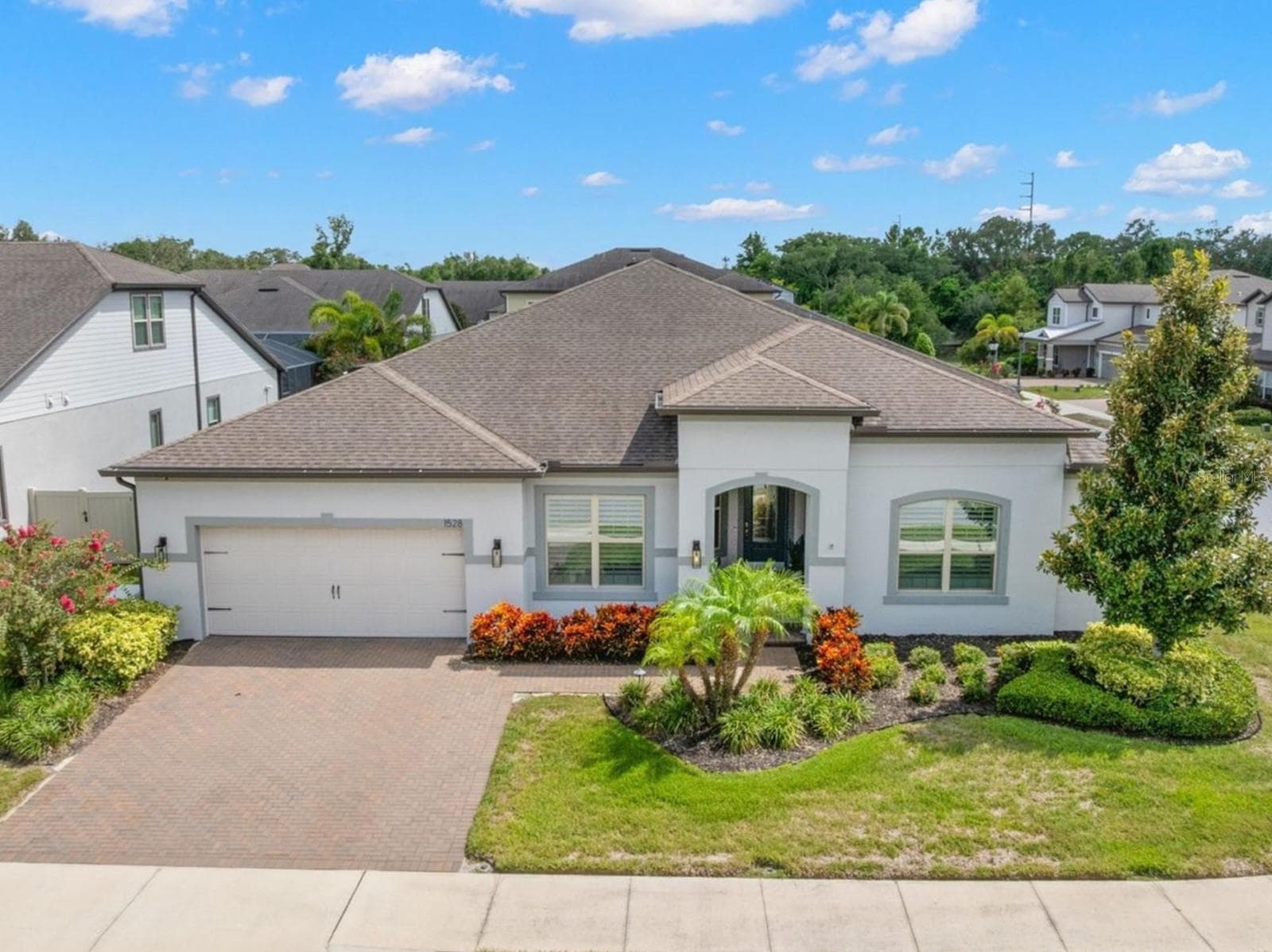 A polished first impression in gated Enclave at Palm Harbor: this single-story 3-bedroom, plus den/Flex room, 2½-bath pool home offers 2,965 square feet, a brick-paver driveway, two-car garage, arched covered entry and beautifully maintained tropical landscaping. - 1528 FOREST GLEN CT, PALM HARBOR