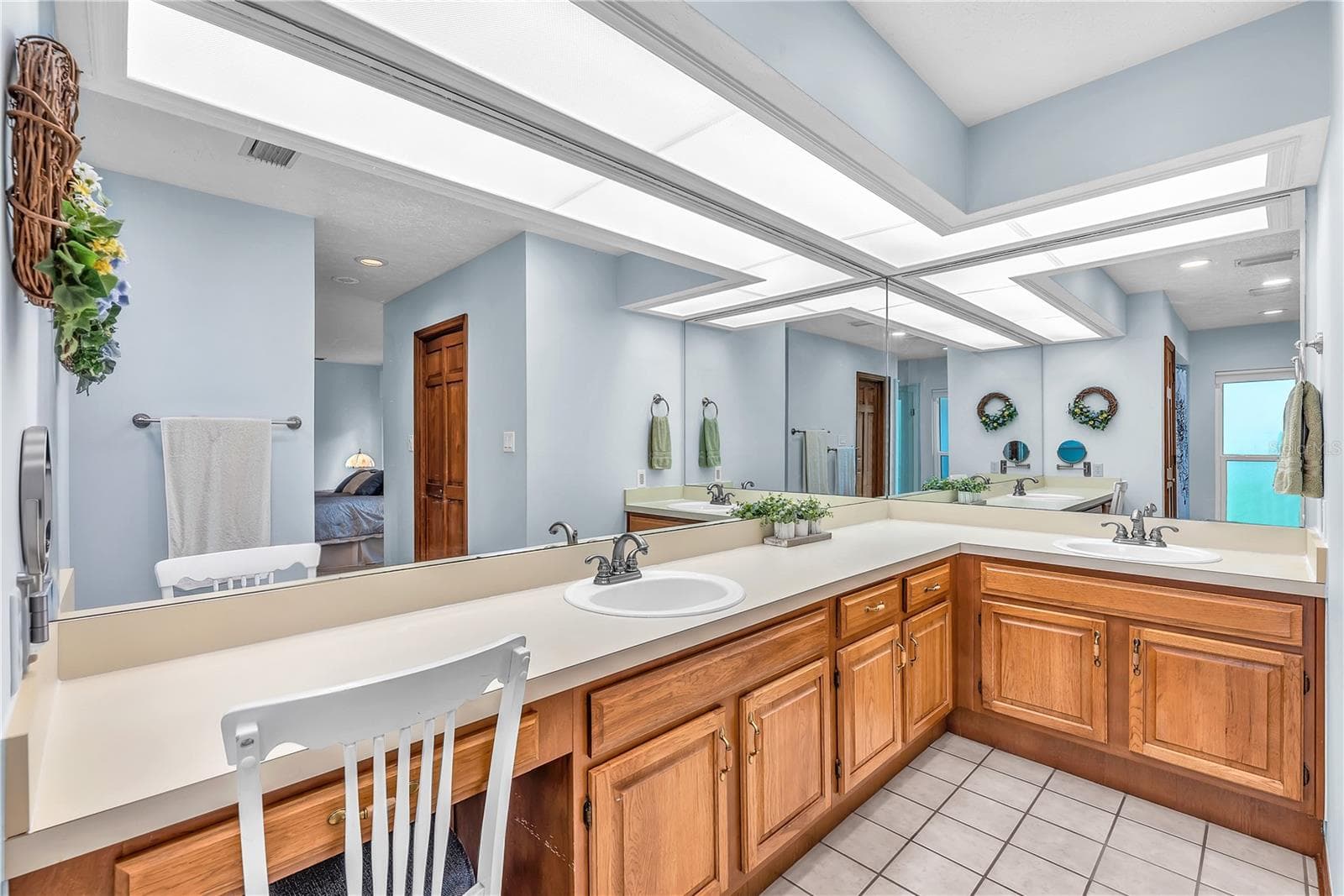 The primary bath features dual sinks, ample storage, and a dedicated makeup vanity for added convenience. - 2421 OAK LANDING DR, BRANDON