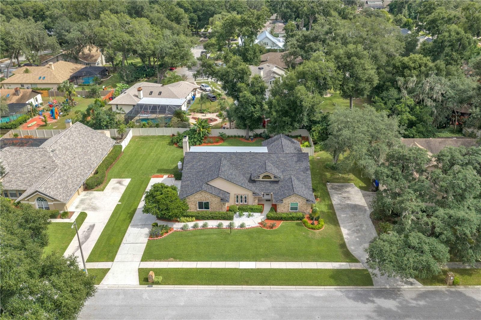 Nestled along a picturesque, tree-lined street surrounded by generously sized homesites, this stunning brick residence offers a rare combination of custom architecture and rich traditional details. - 2421 OAK LANDING DR, BRANDON
