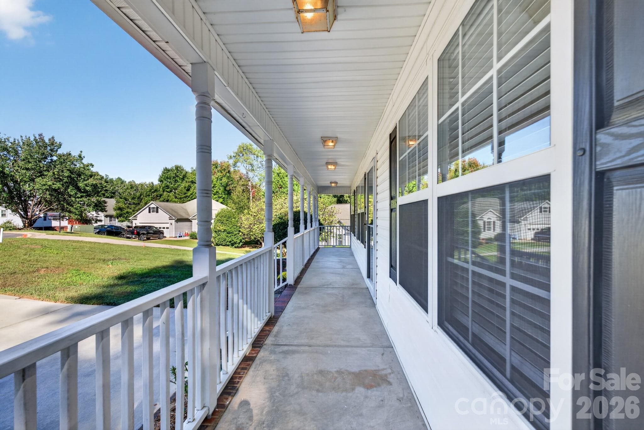 Deep, shaded front porch complete with ceiling fans, offering an exceptionally breezy outdoor living area. - 702 Painted Lady Court, Rock Hill