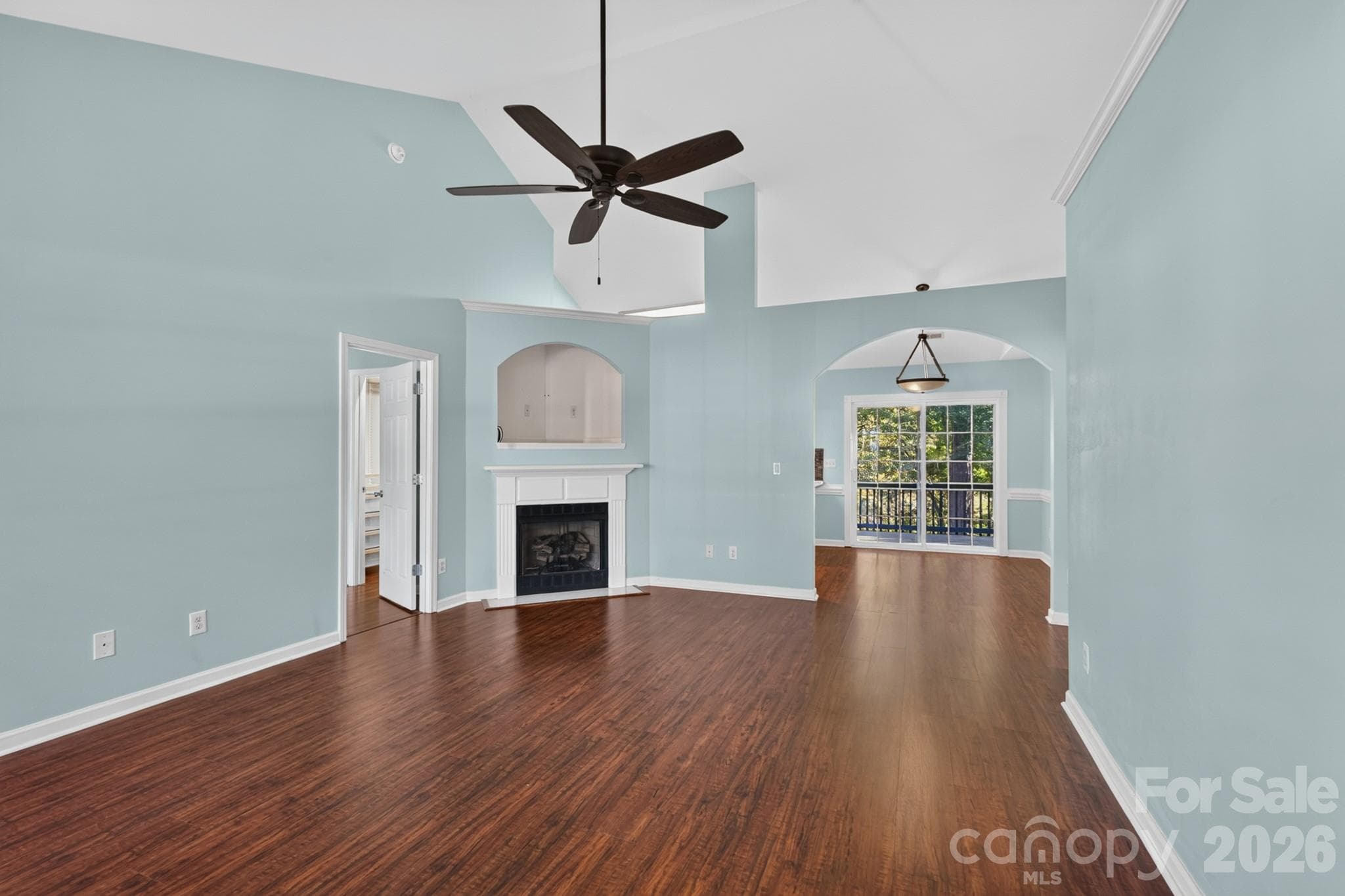 Light-filled living room featuring soaring vaulted ceilings, warm hardwood floors, and a bright, open feel. - 702 Painted Lady Court, Rock Hill