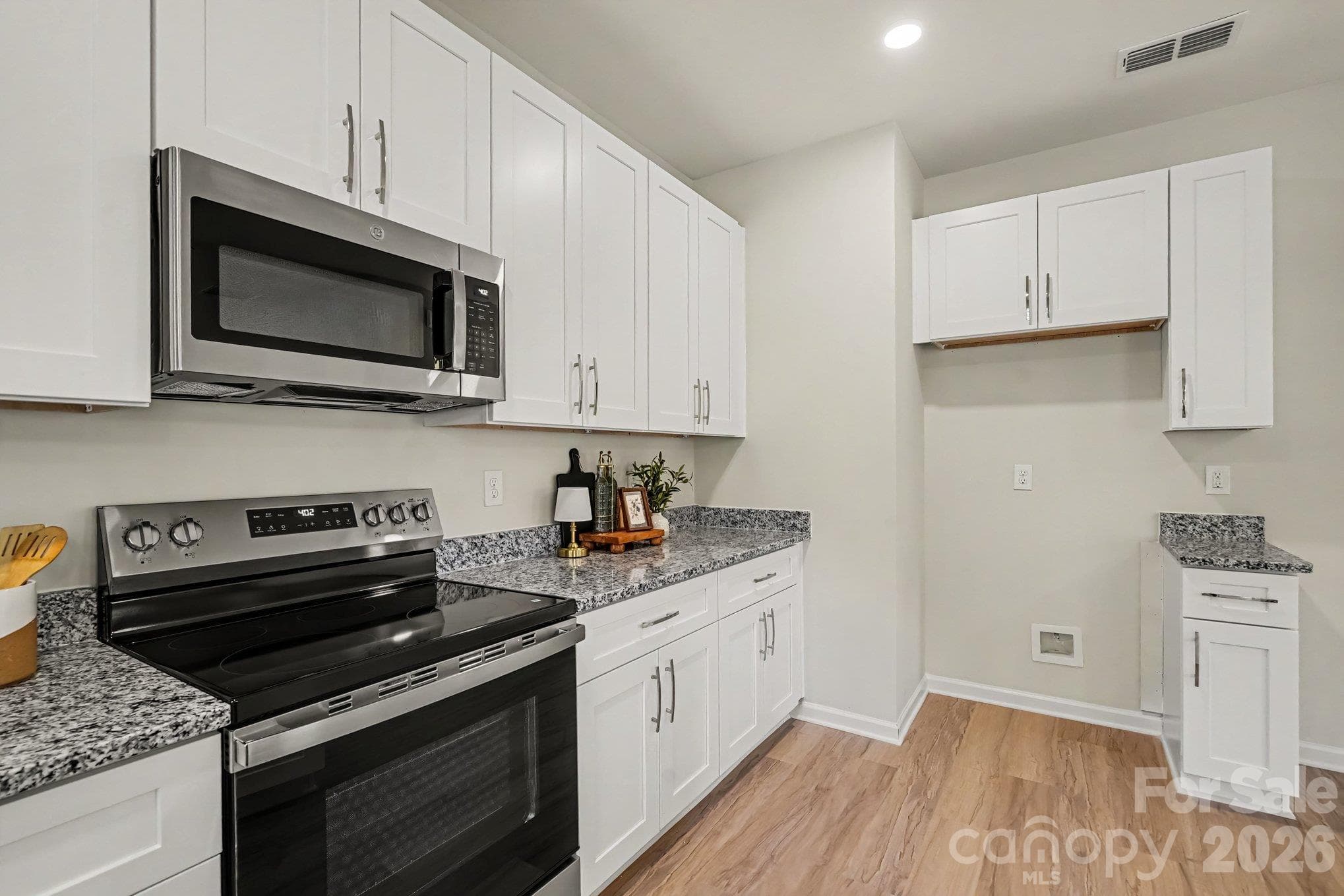 Electric range and microwave are in place with an ice maker connection for a refrigerator. This photo is a representation of home taken from identical home next door. Actual photos are in process. - 125 Buffalo Avenue NW, Concord