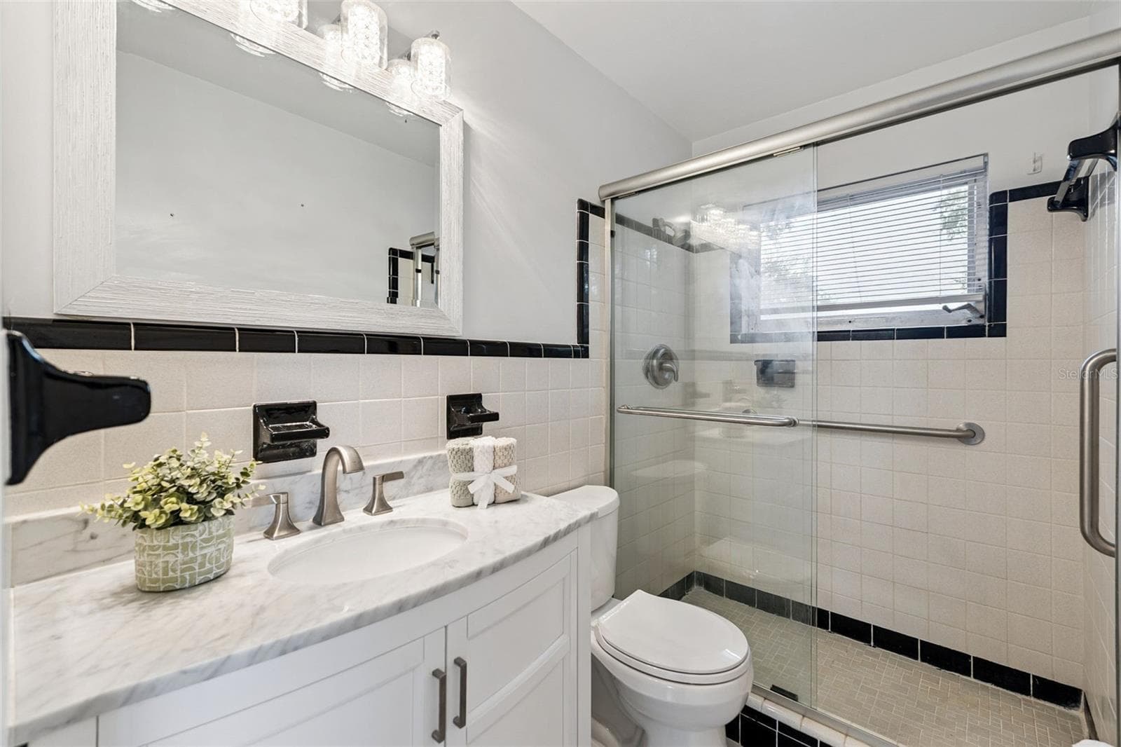 2nd Floor Primary En-suite bath with comfort height vanity adorned with granite countertop and walk-in shower with safety grab bars - 803 HILLSIDE AVE, LAKE WALES