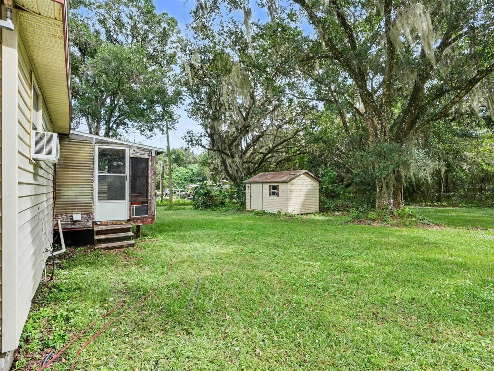 Main residence with adjacent structures amid lush grounds - 3015 STRAWBERRY LN, LAKELAND