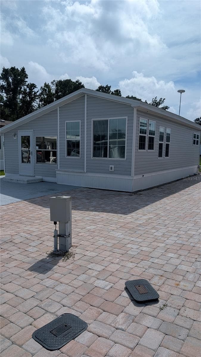 EAST SIDE VIEW. NOTE PAVED AREA - 207 CITRUS RIDGE DR, DAVENPORT
