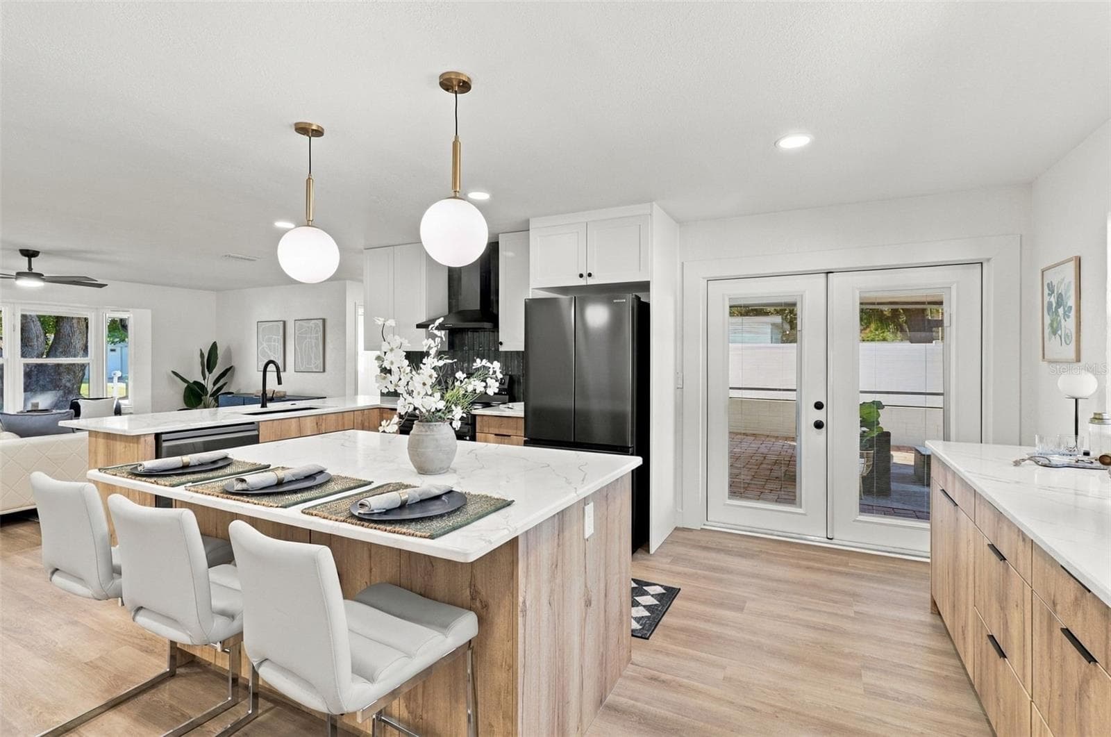 Beautifully updated kitchen featuring quartz countertops, stainless steel appliances, and French doors leading to the outdoor living area. - 11218 116TH ST, SEMINOLE