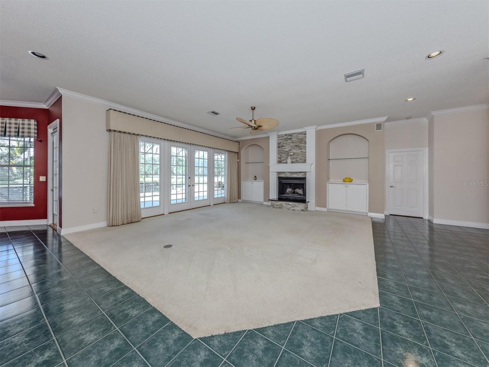 The great room includes built-ins, propane fireplace, and large french doors that lead to the lanai and open to the kitchen and dining room - 1725 ARDRY WAY, VENICE