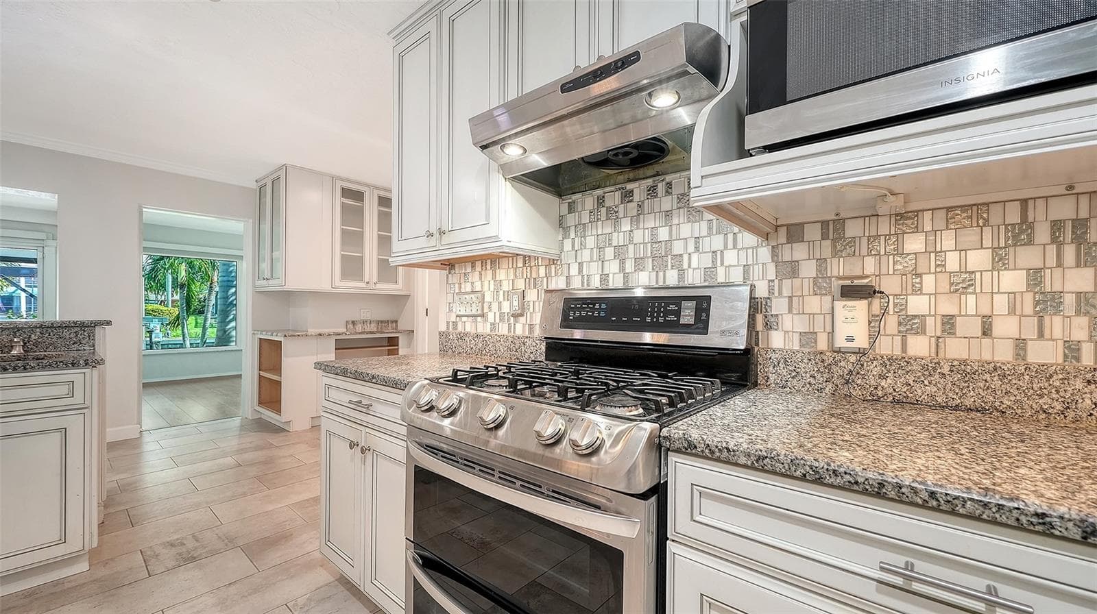 A gas range and detailed tile backsplash anchor the kitchen. - 4907 CORAL BLVD, BRADENTON