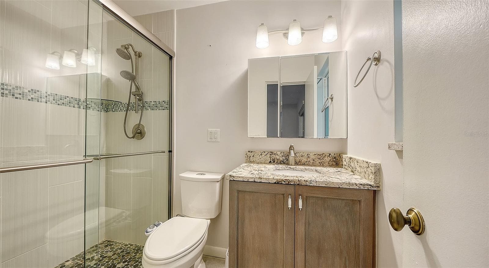 A bathroom with a glass-enclosed shower and generous vanity. - 4907 CORAL BLVD, BRADENTON