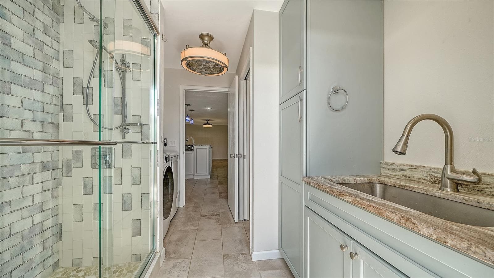A poolside bathroom with a glass shower for easy refreshment. - 4907 CORAL BLVD, BRADENTON