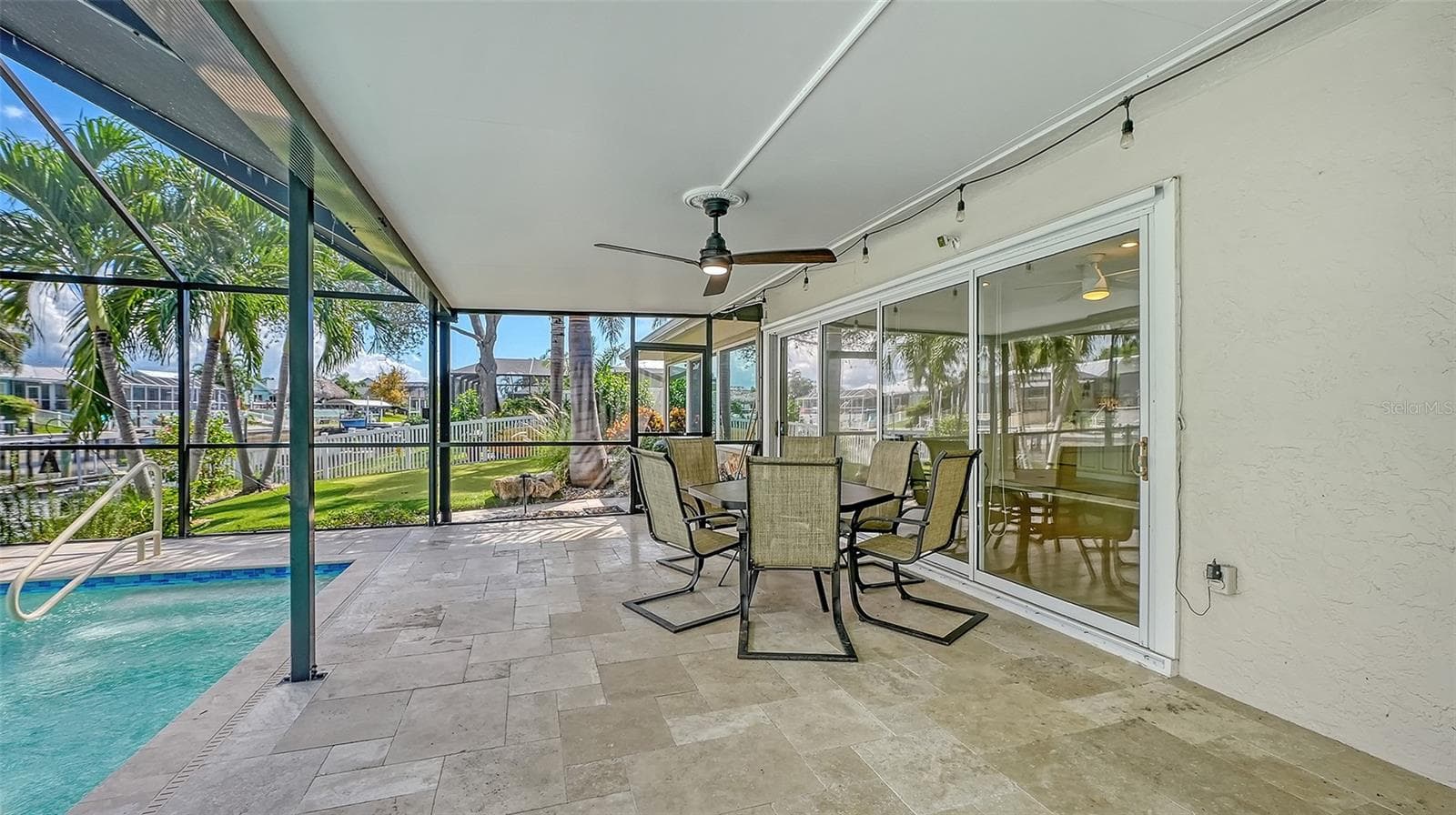 Covered outdoor dining with views of the pool and canal. - 4907 CORAL BLVD, BRADENTON