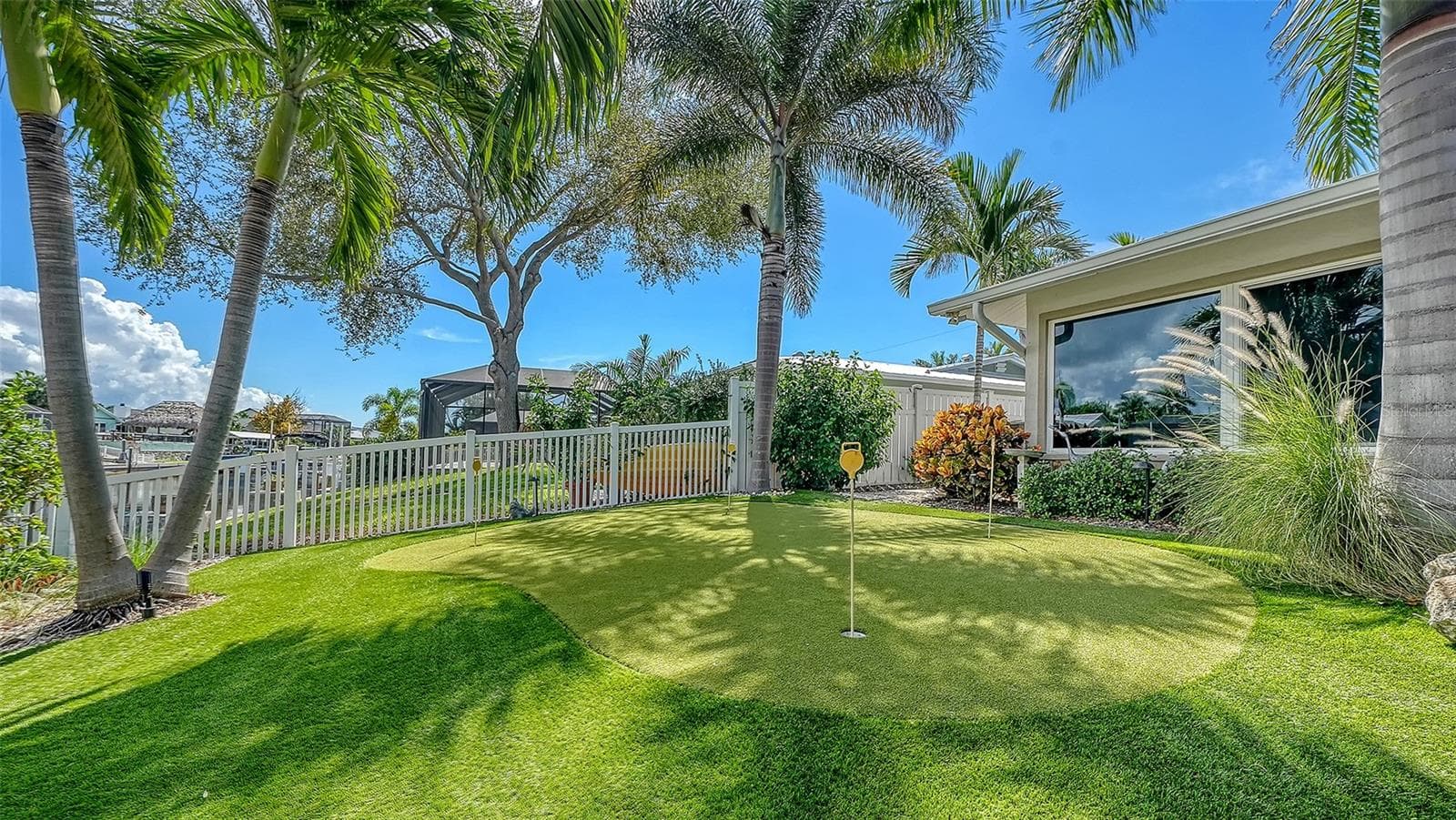 A palm-lined putting green beside the waterfront setting. - 4907 CORAL BLVD, BRADENTON