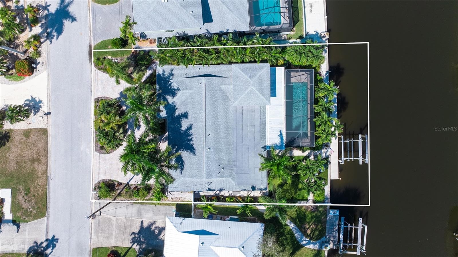 An overhead view shows the home, pool enclosure, and waterfront layout. - 4907 CORAL BLVD, BRADENTON