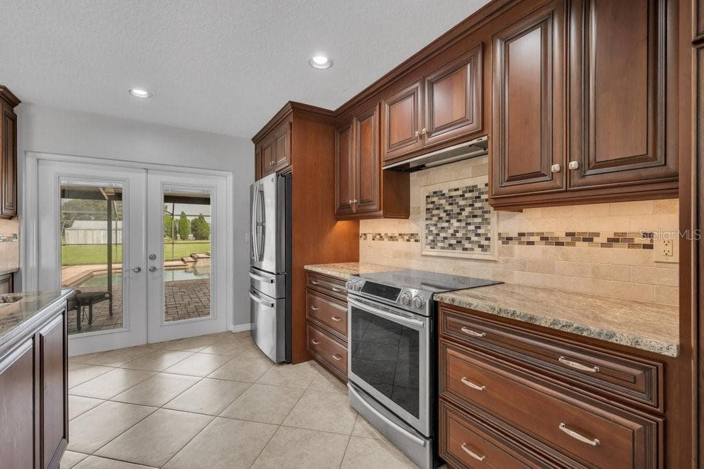 Kitchen showing access to pool through the French doors - 5710 WO GRIFFIN RD, PLANT CITY