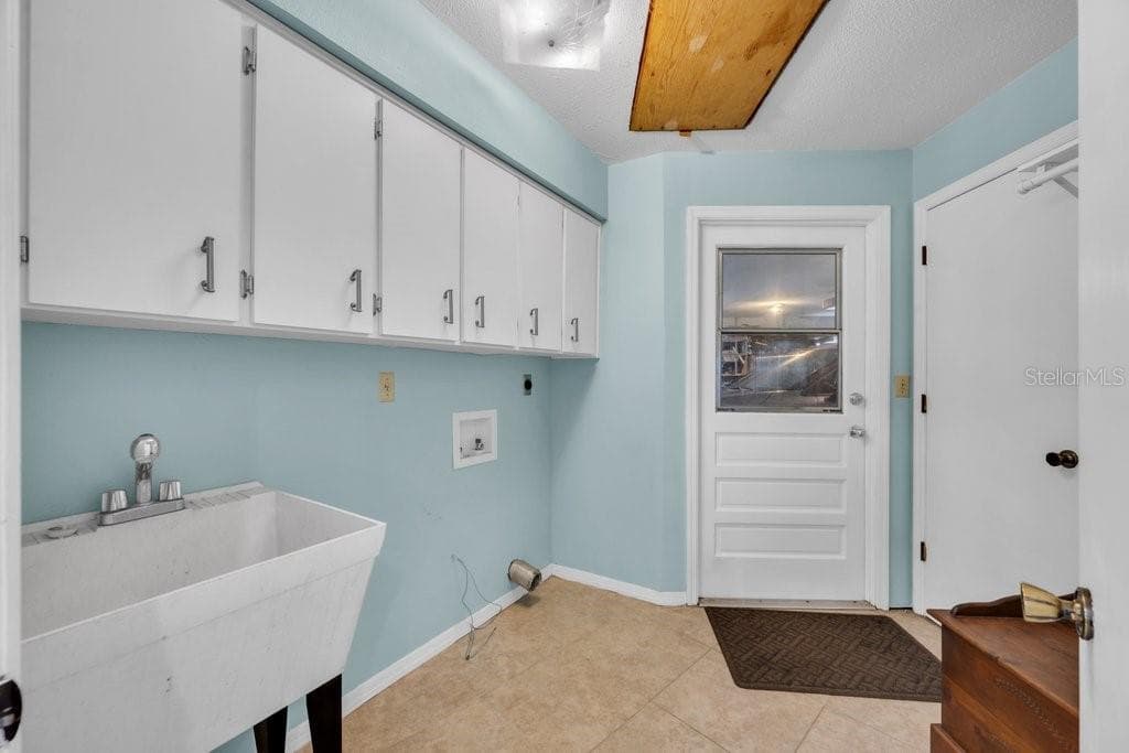 Laundry room with utility sink. Door leads out to garage - 5710 WO GRIFFIN RD, PLANT CITY