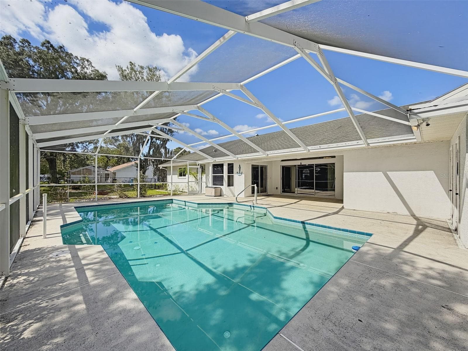 Heated saltwater swimming pool with bath, outdoor shower, and storage. - 10074 SLEEPY WILLOW CT, SPRING HILL