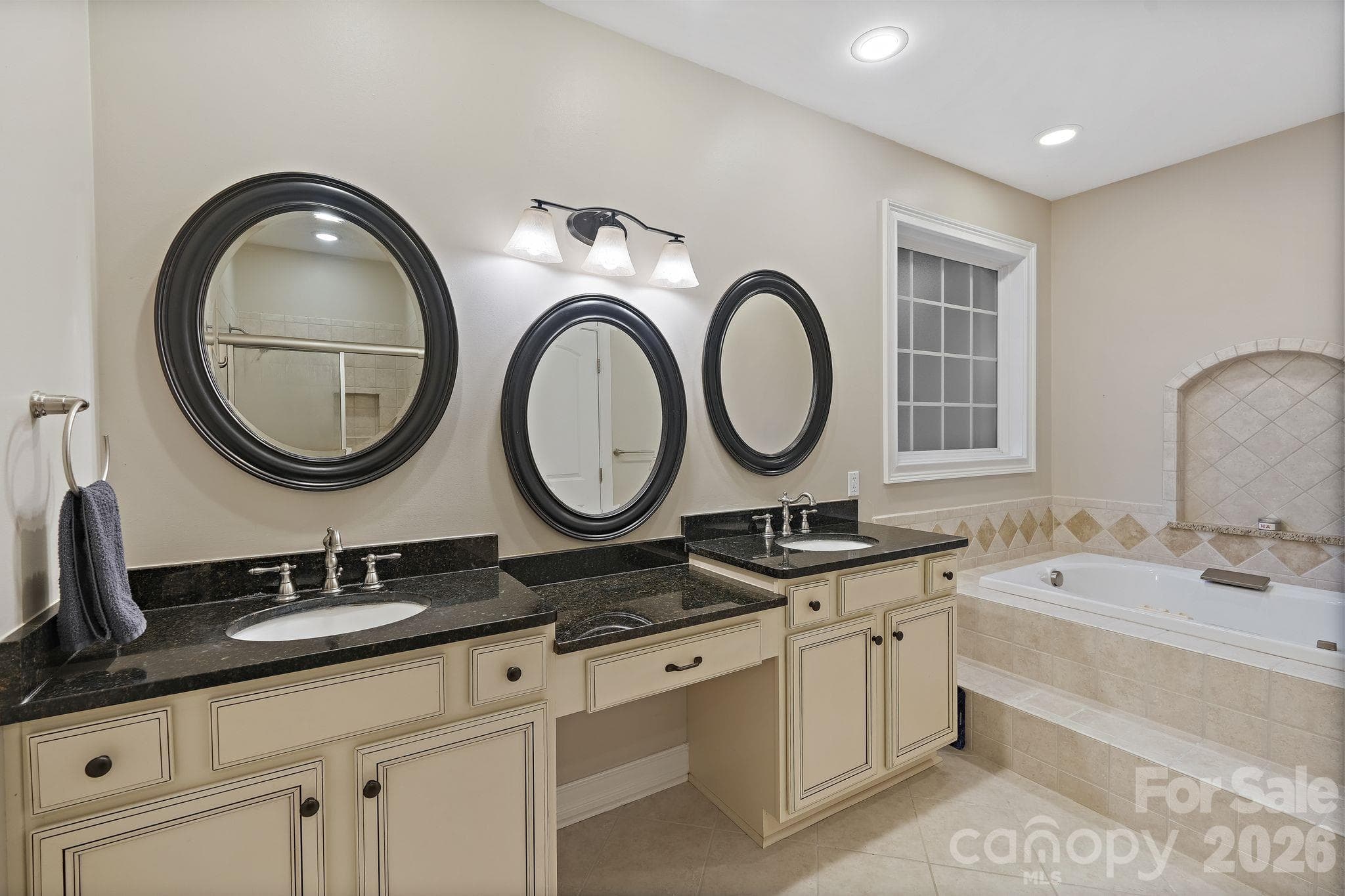 Primary bathroom with dual vanities and jetted bathtub - 1491 Woodbend Court, Stanley