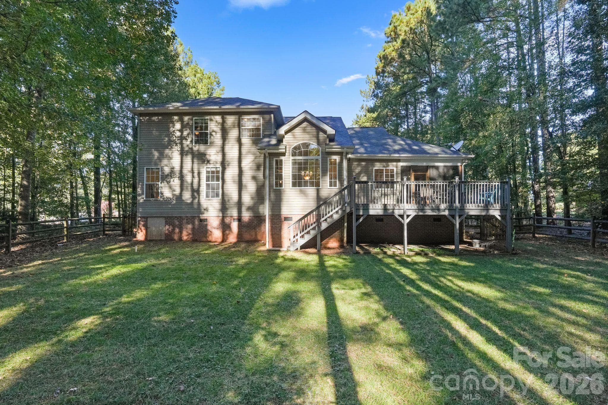 Level fenced yard surrounded by mature trees. - 1491 Woodbend Court, Stanley