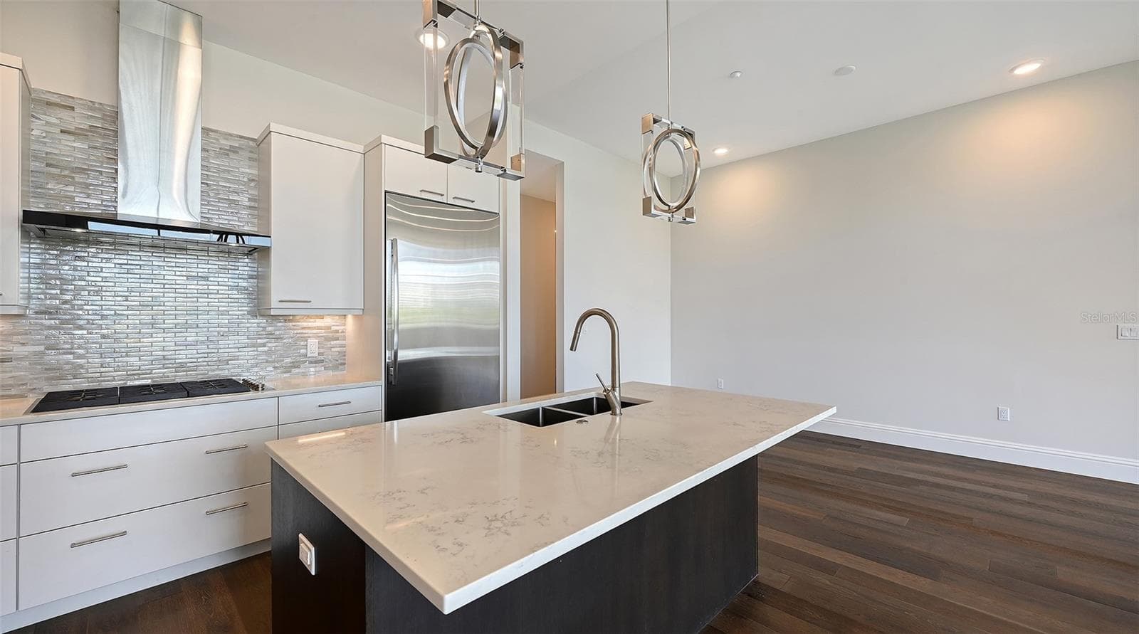 Kitchen area showing cooktop, refrigerator and into breakfast eat in area - 609 GOLDEN GATE PT #301, SARASOTA