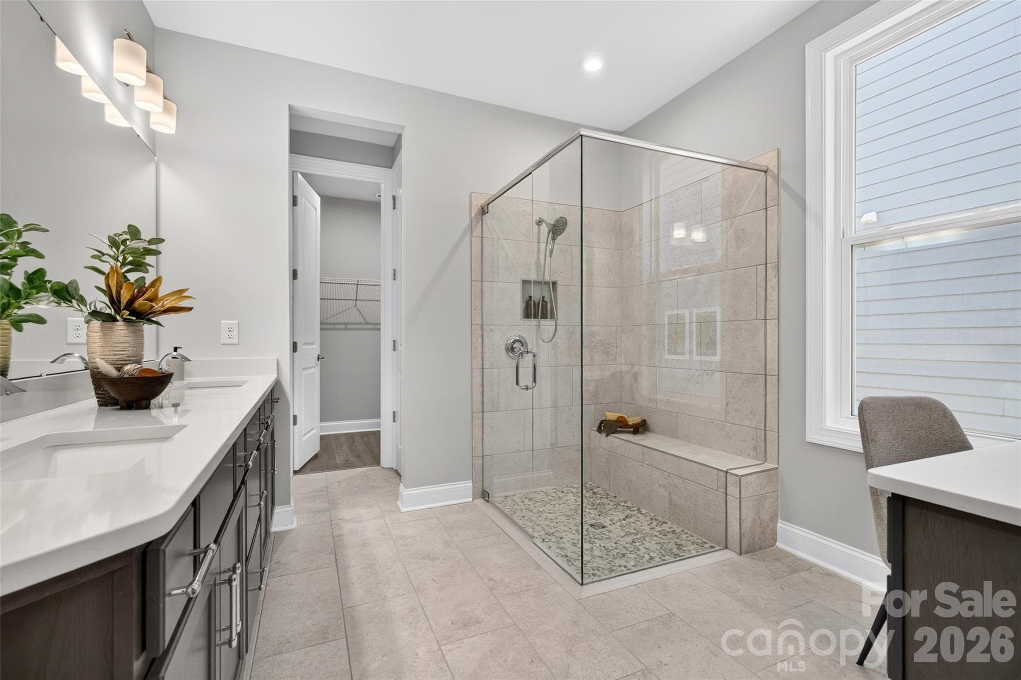 Primary ensuite bath has luxury shower with full glass surround and tiled seat - 13413 Cozy Court, Charlotte