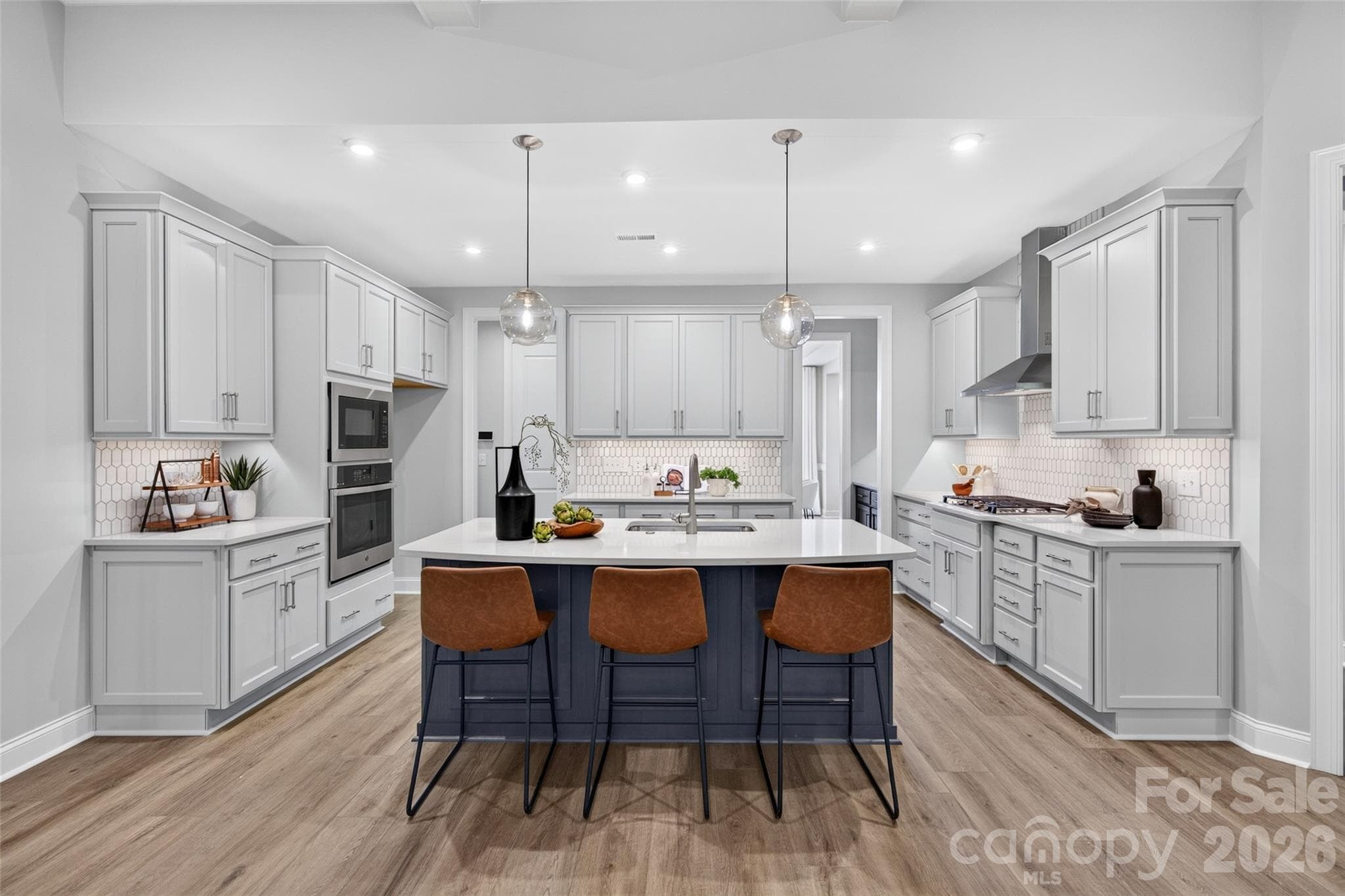 Plenty of cabinetry in this gourmet Kitchen with gas cooktop, wall ovens and stainless steel exhaust hood - 13413 Cozy Court, Charlotte
