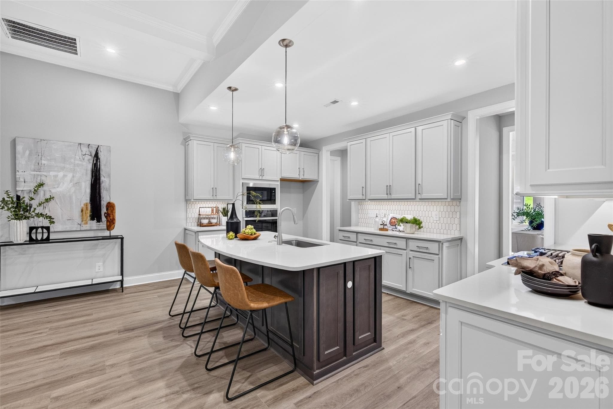 Custom tile backsplash, quartz counters, undermount lighting and a center island in a contrasting accent color - 13413 Cozy Court, Charlotte