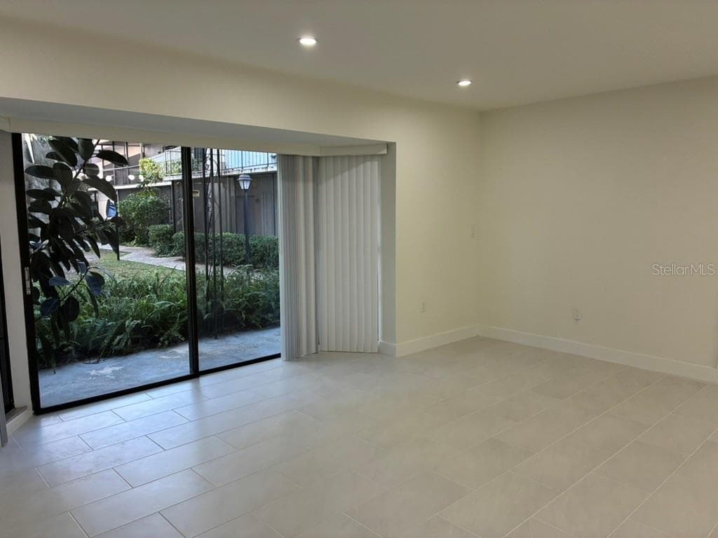 Living room and view of rear porch - 5999 VILLAGE CIR #990, ORLANDO