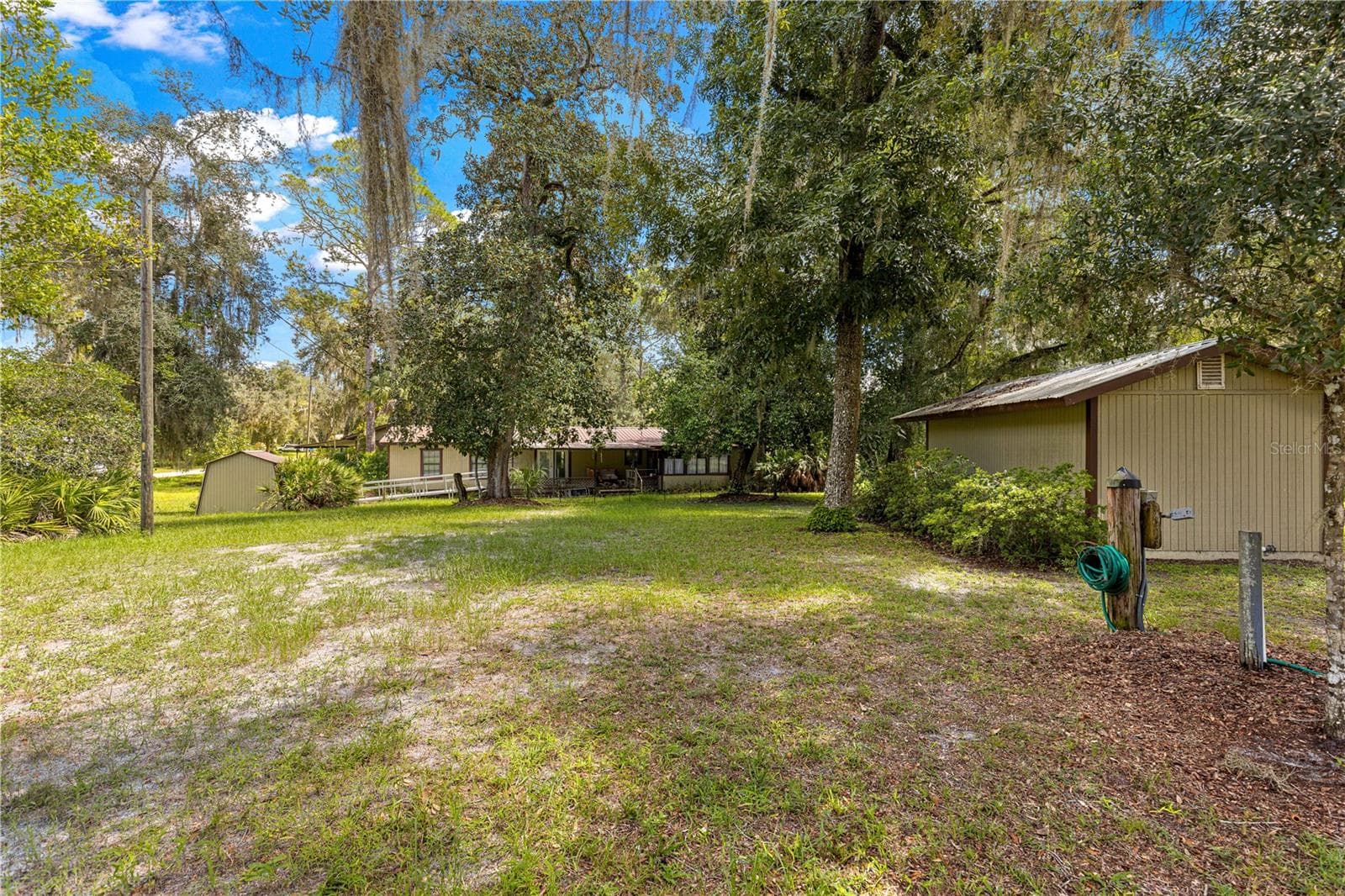 Lawn between the main residence and surrounding outbuildings. - 7434 E CABIN LN, INVERNESS