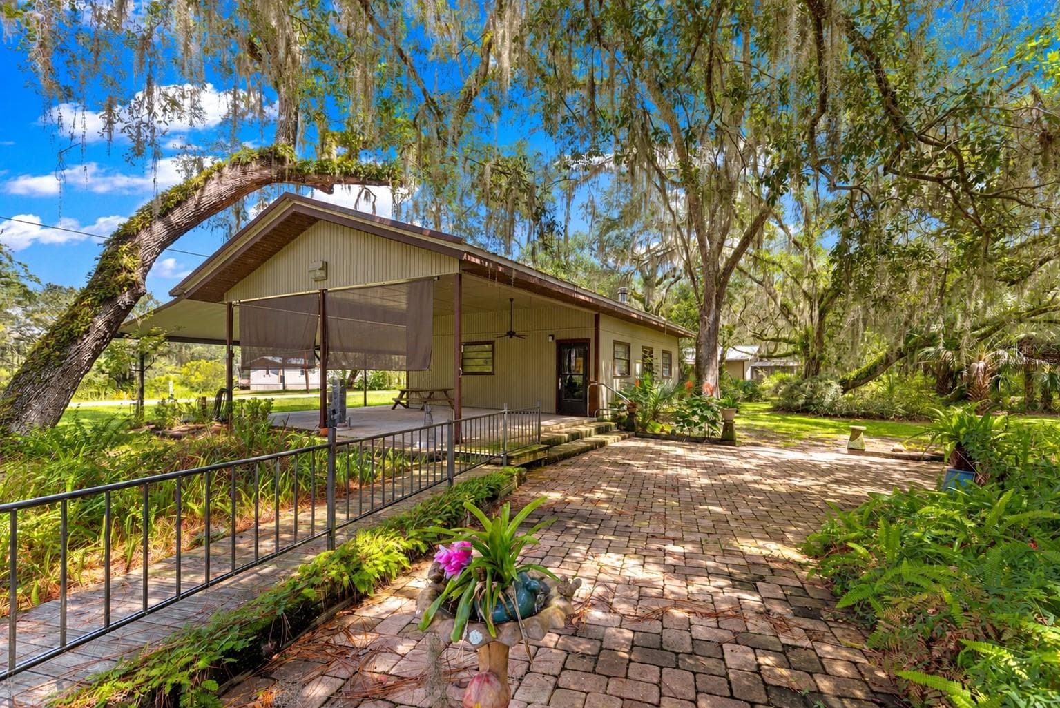 #2 · Mechanic’s shop, covered entry and courtyard approach. Virtually staged—personal items digitally removed. - 7434 E CABIN LN, INVERNESS