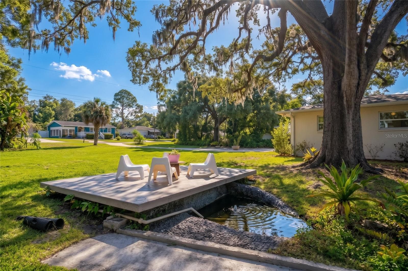 A private manicured spring with a patio perched in the shade of mature landscaped trees. This spring stays around 70 degrees and is perfect for a quick cool off in hot weather - 7308 N OLA AVE, TAMPA