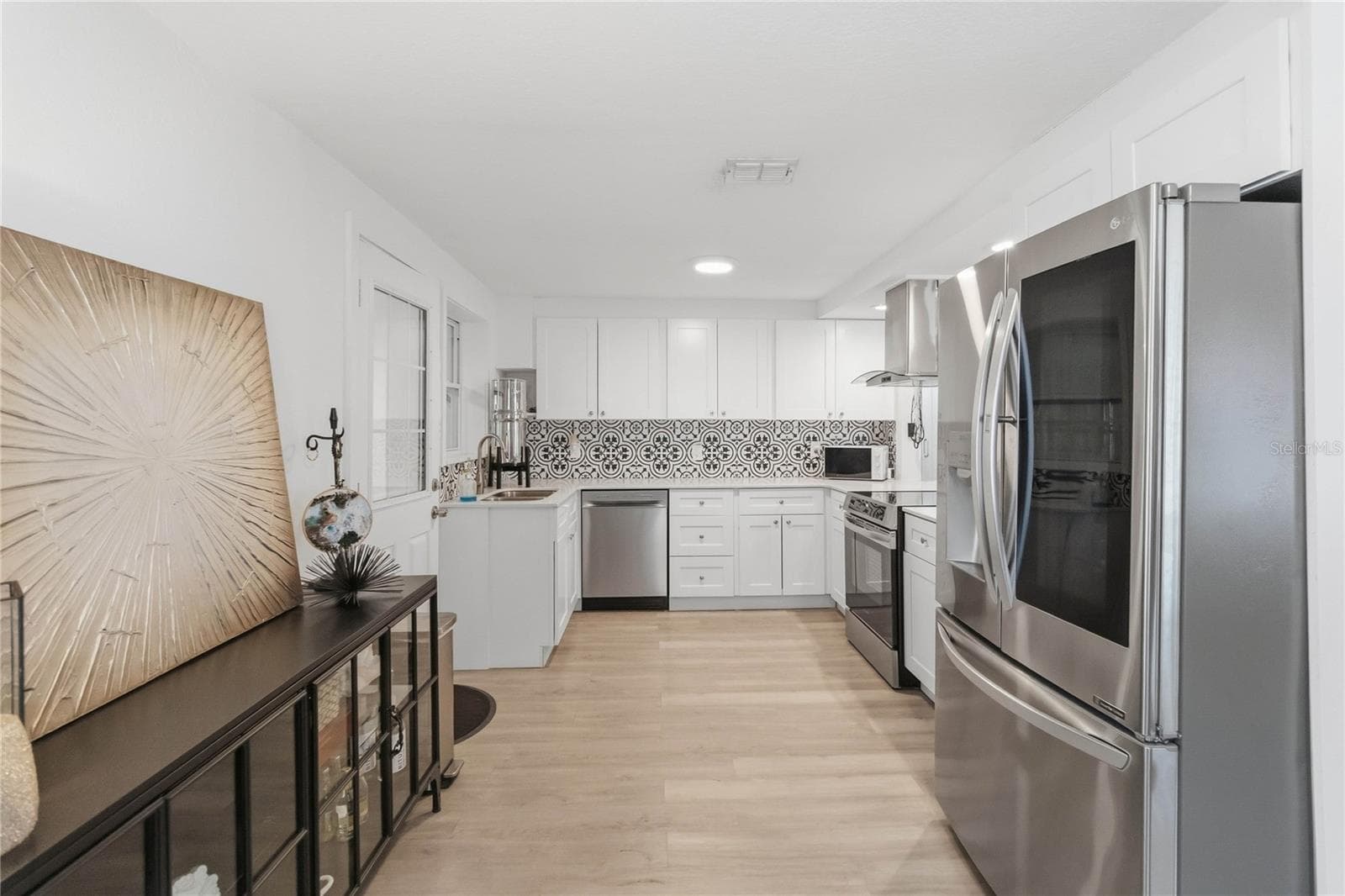The stunning kitchen with quartz counters and stainless steel appliances including an induction stove with convection oven that is 3 months old. - 438 VIRGINIA AVE, ST CLOUD