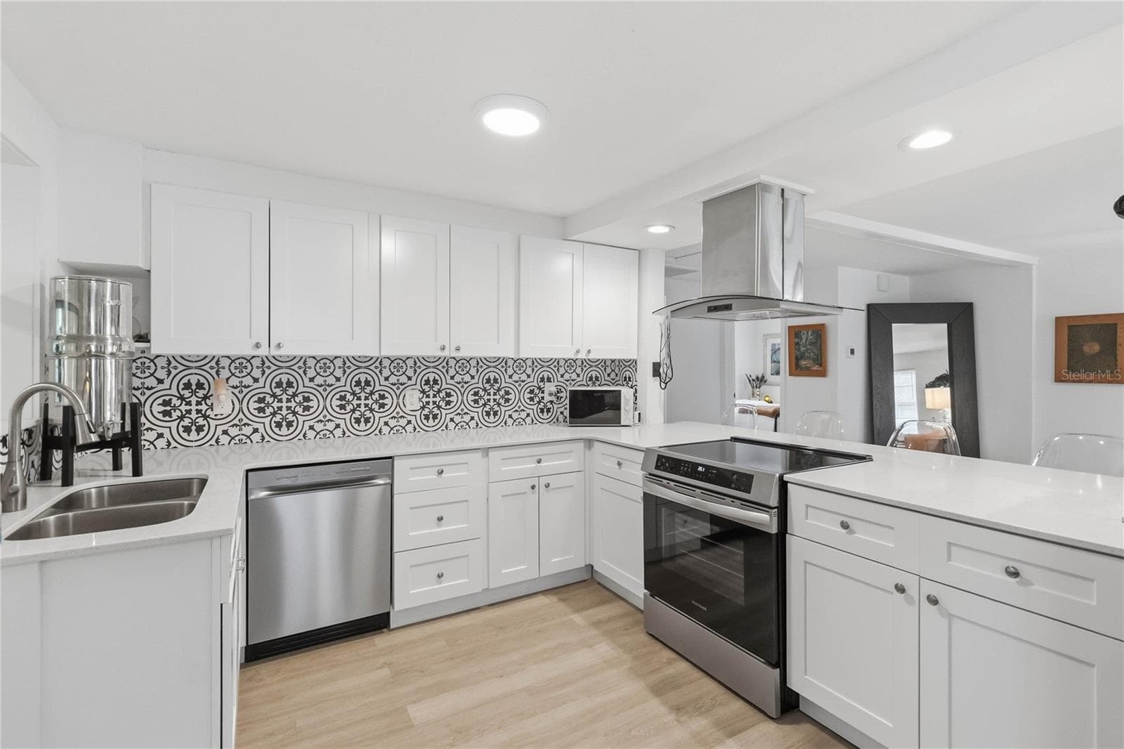 The stunning kitchen with quartz counters and stainless steel appliances including an induction stove with convection oven that is 3 months old. - 438 VIRGINIA AVE, ST CLOUD
