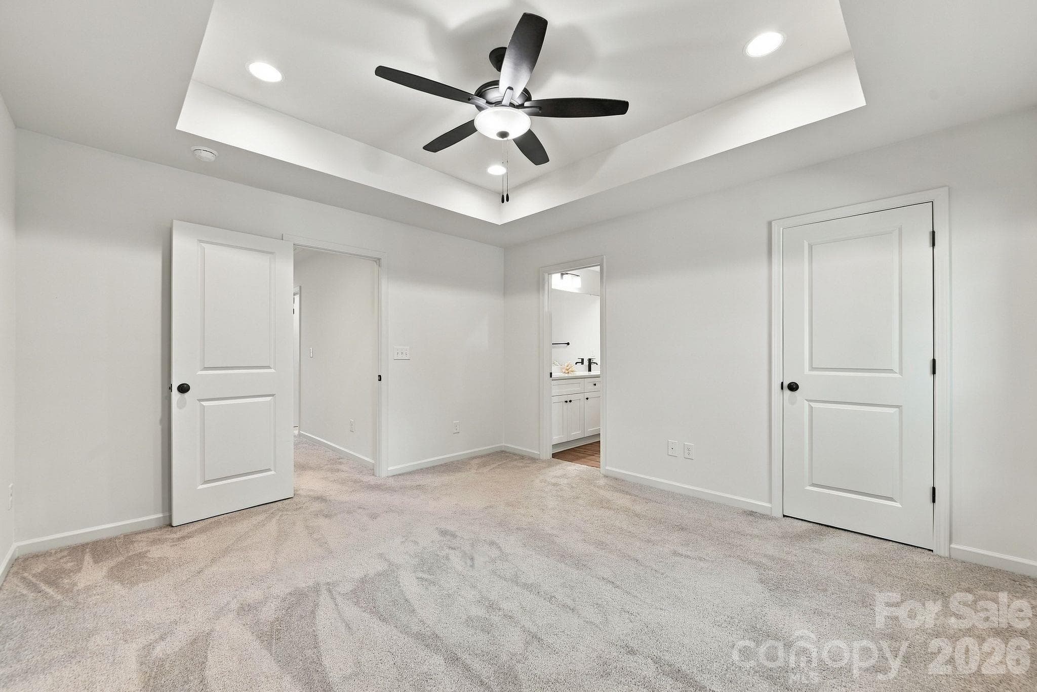 Primary bedroom with tray ceiling overlooks tree-lined yard for privacy - 4715 Crestmont Drive, Charlotte